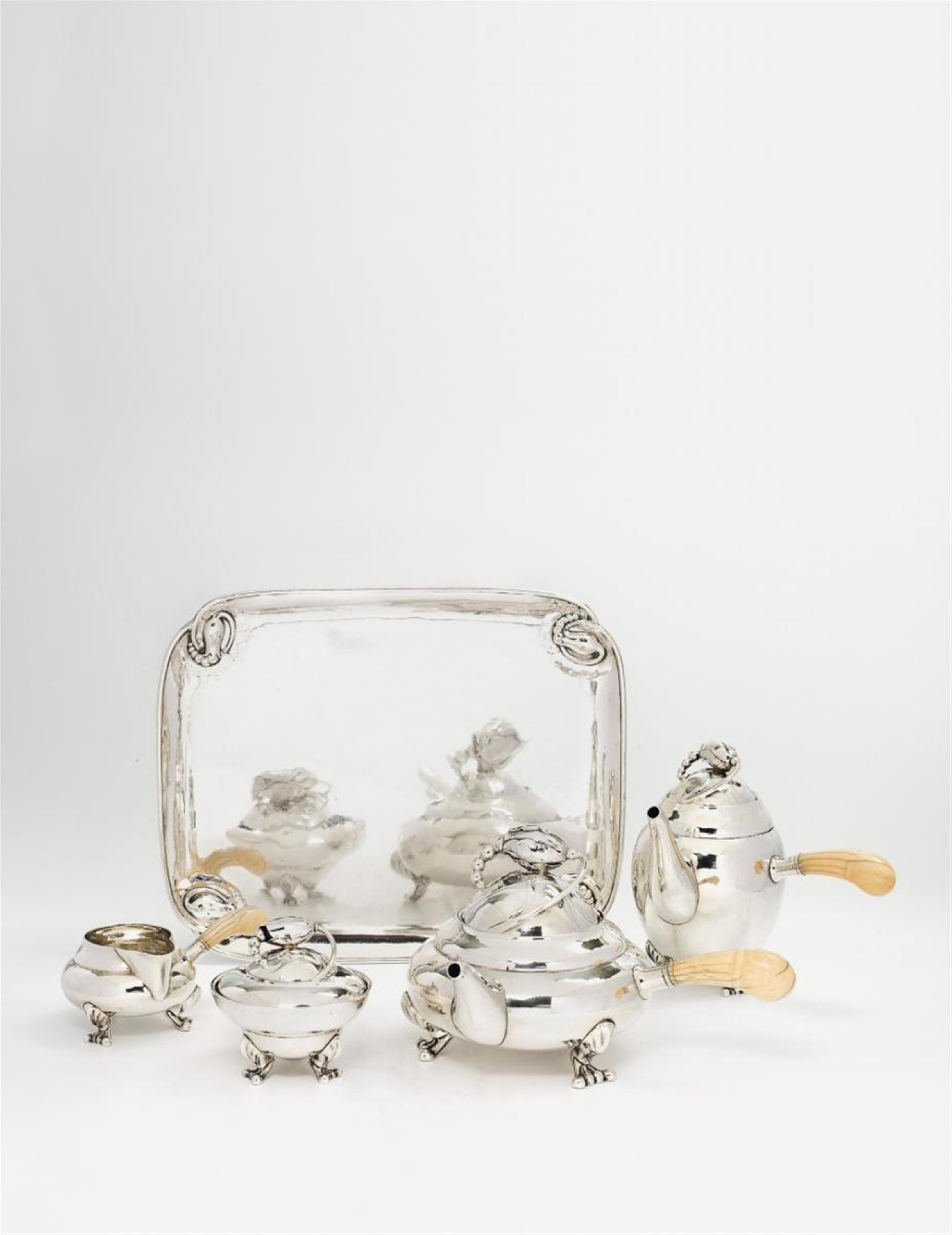 A silver blossom pattern coffee and and tea service no. 2. Comprising coffee and tea pots with ivory handles, milk jug, sugar box and tray. Marks of Georg Jensen, designed in 1904/05, made from ca. 1915 - 30. - image-1