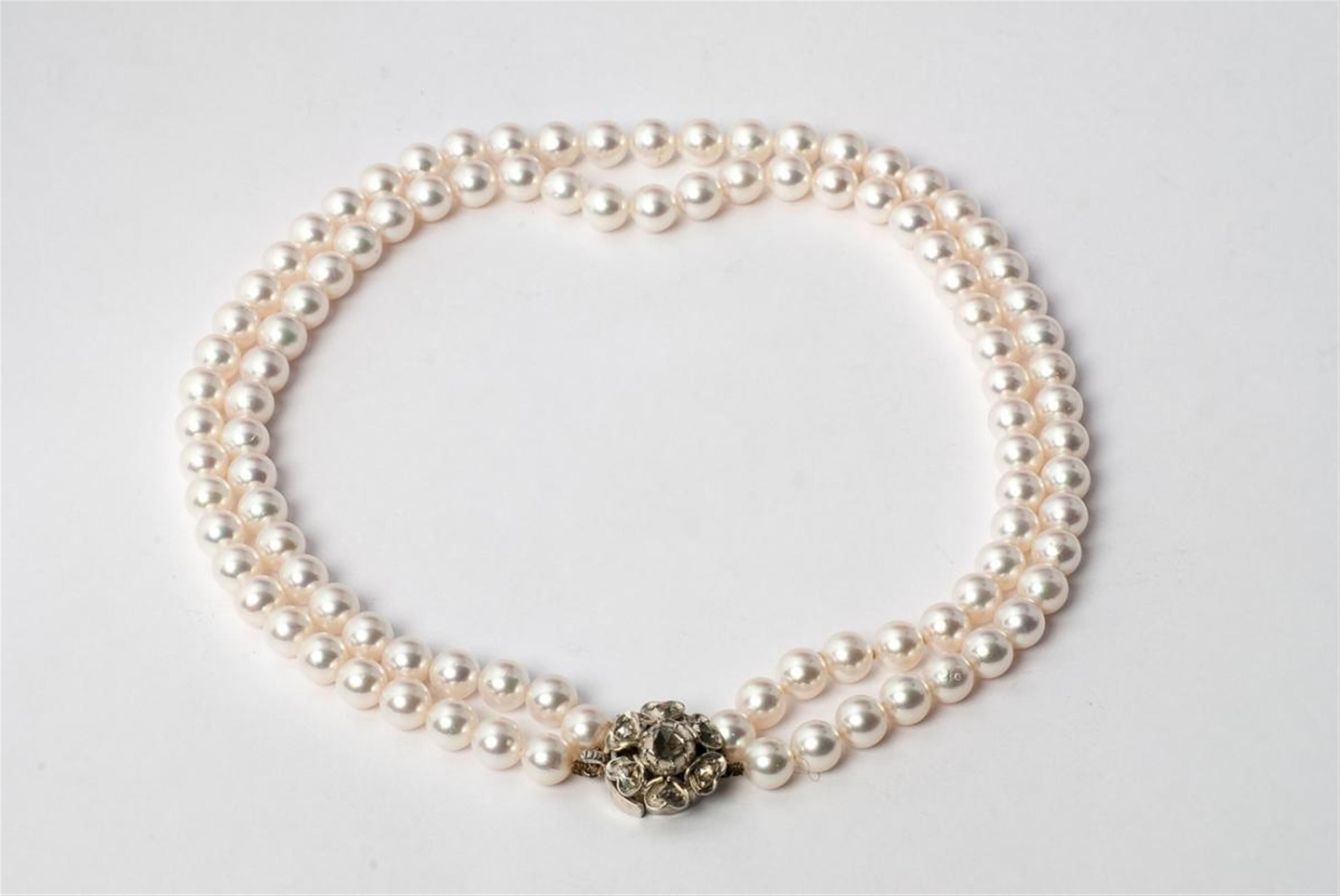 A two-stranded Akoya pearl necklace with diamond-set silver clasp. - image-1