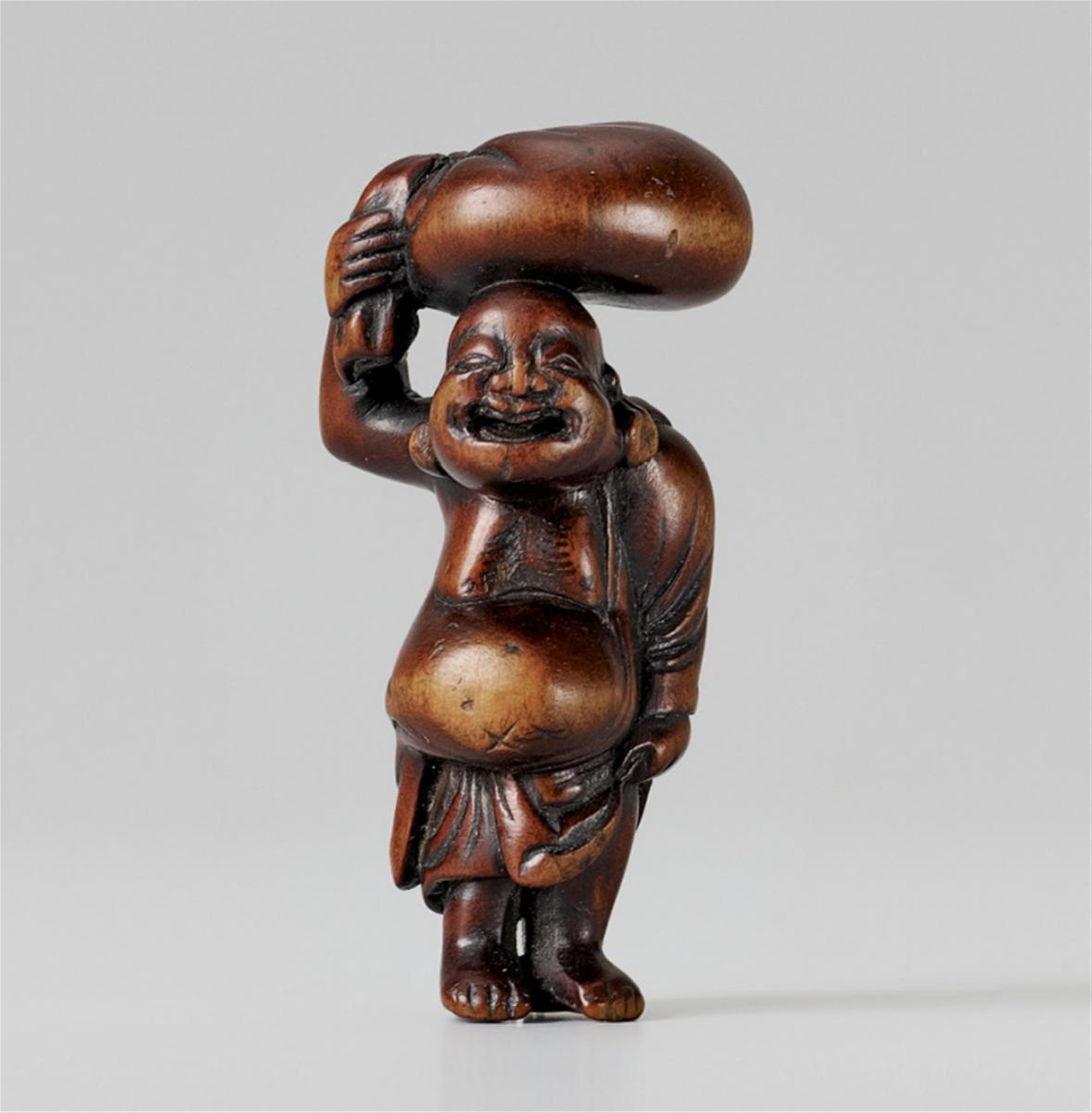 A well worn boxwood netsuke of a pot-bellied Hotei. Late 18th century - image-1