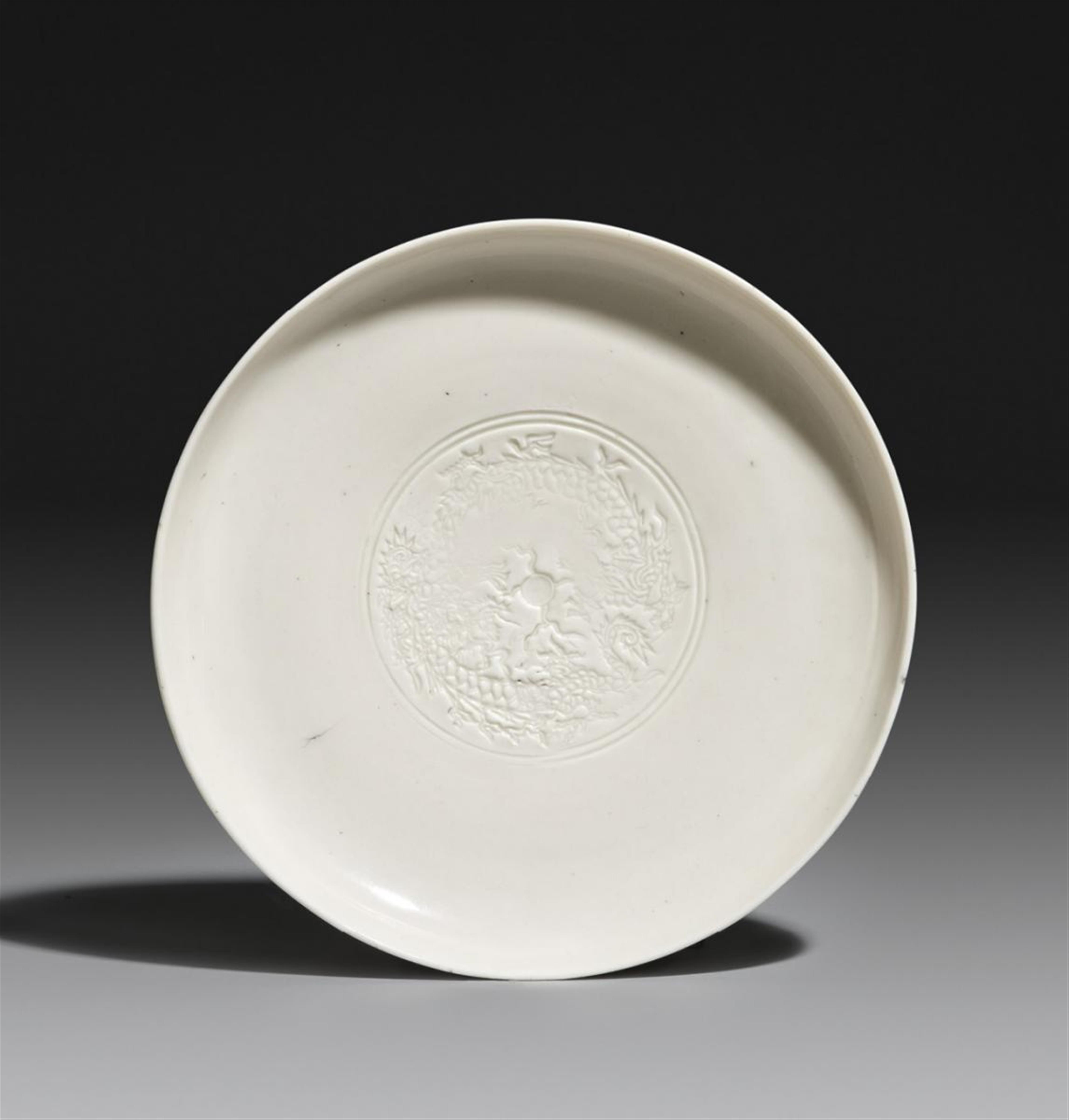 A heavily potted blanc-de-Chine saucer-dish with impressed dragon design. Dehua. 17th century - image-1