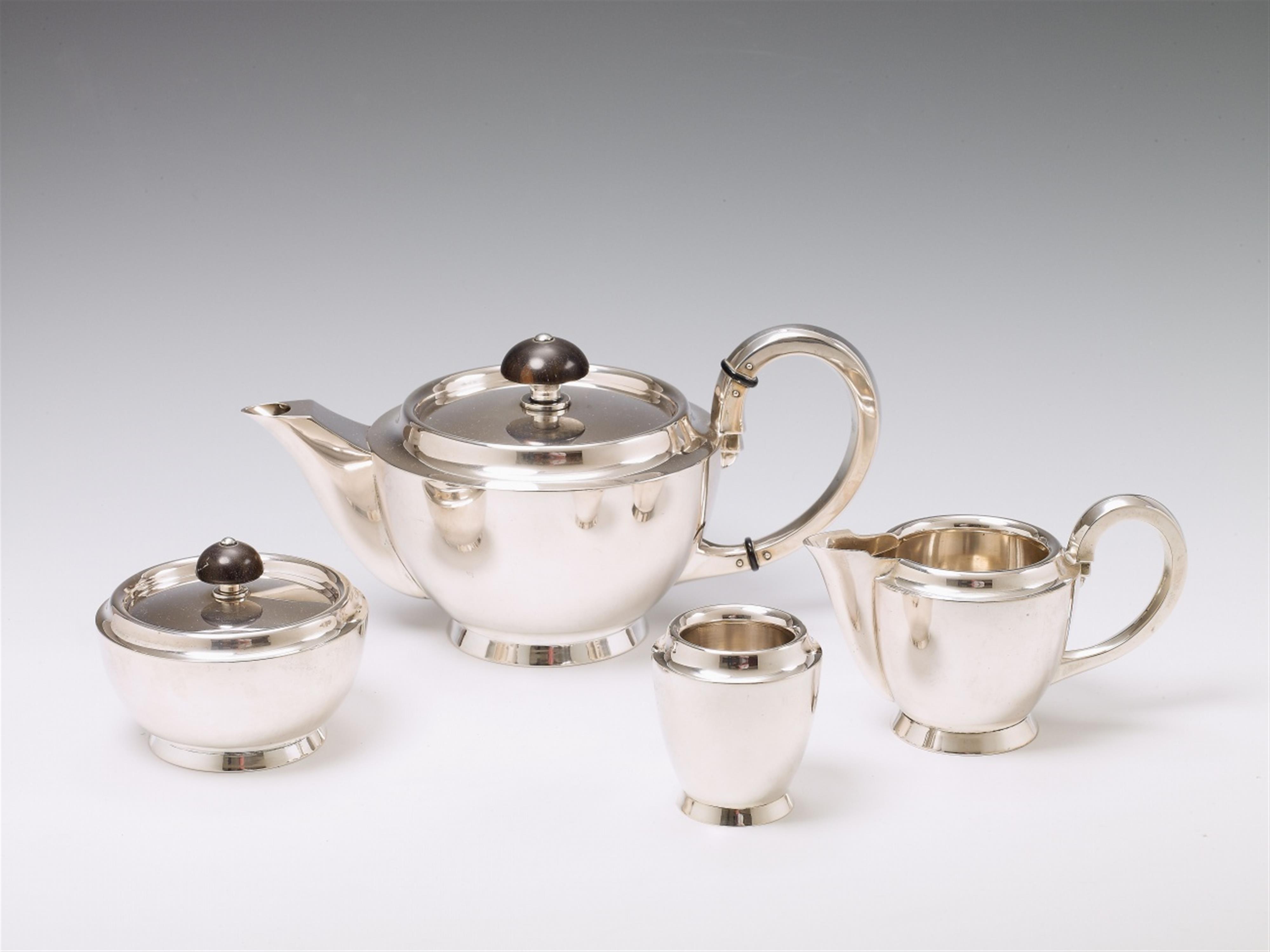 A Schwäbisch Gmünd art déco silver tea service. Comprising teapot, sugar box, milk jug and spoonrest. The finials of ebony. Marks of Jakob Grimminger, ca. 1930. - image-1