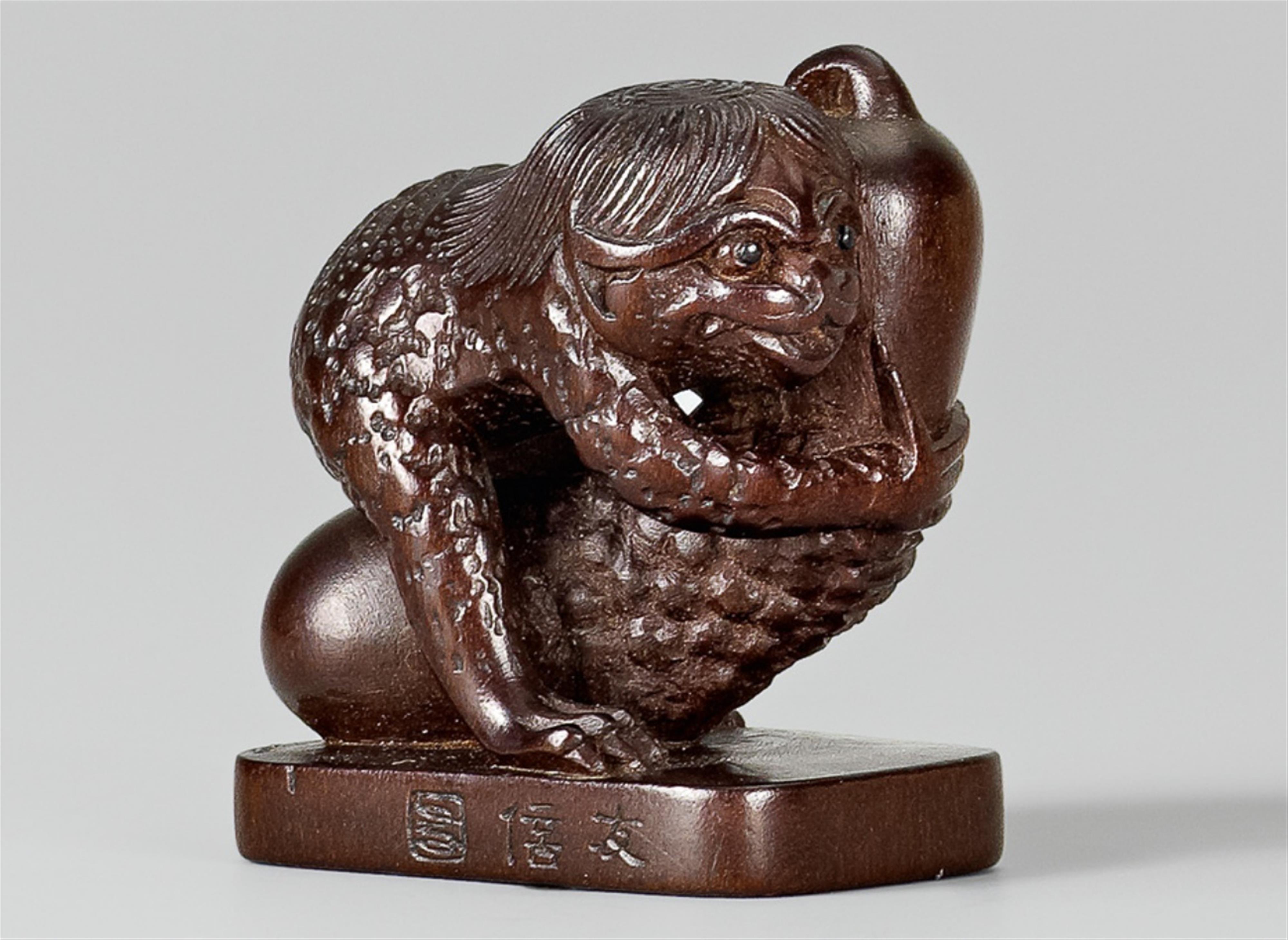 A wood netsuke of a kappa with a cucumber, by Tomonobu. Second half 19th century - image-1