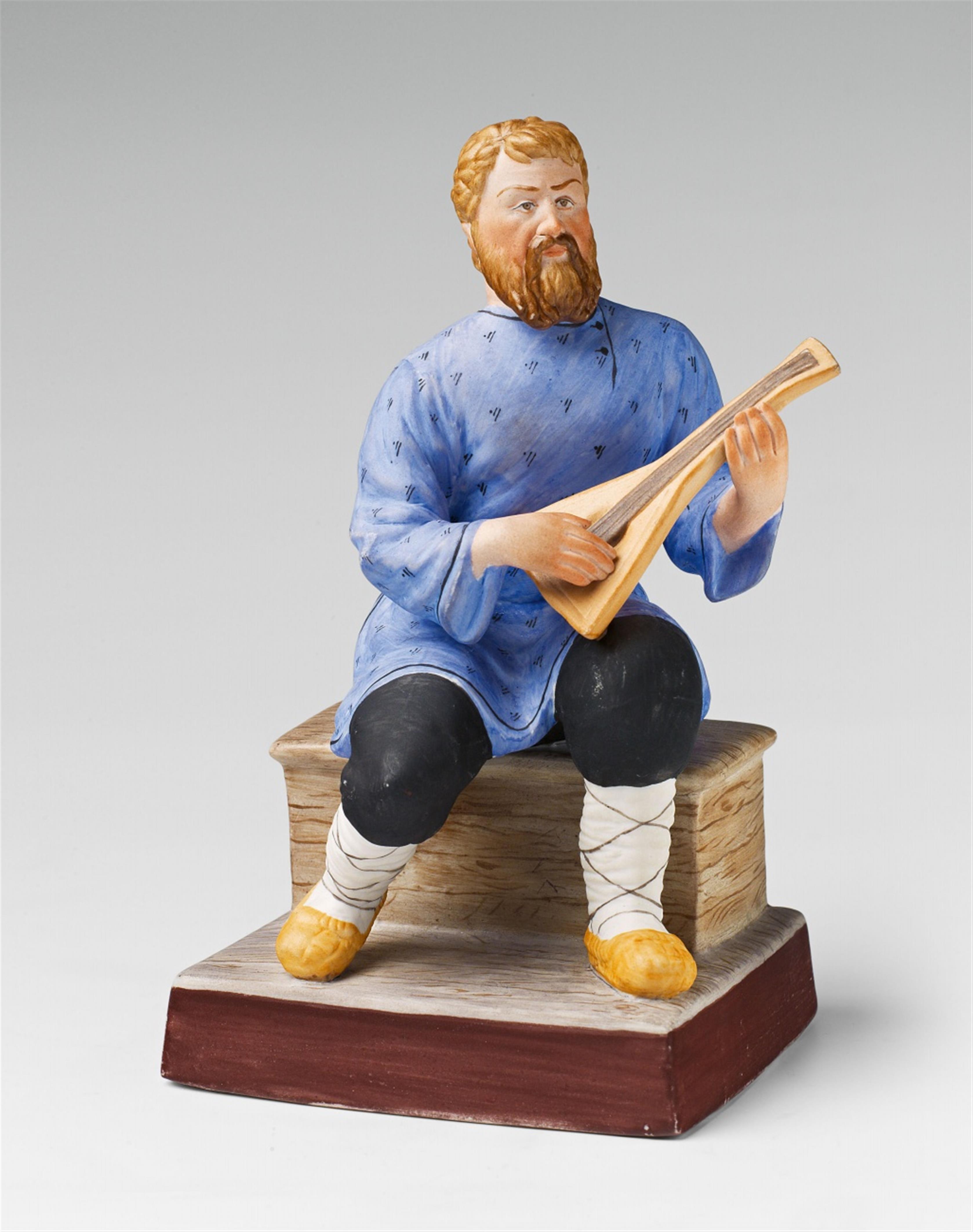 A Moscow biscuit porcelain figure of a peasant with a balalaika - image-1