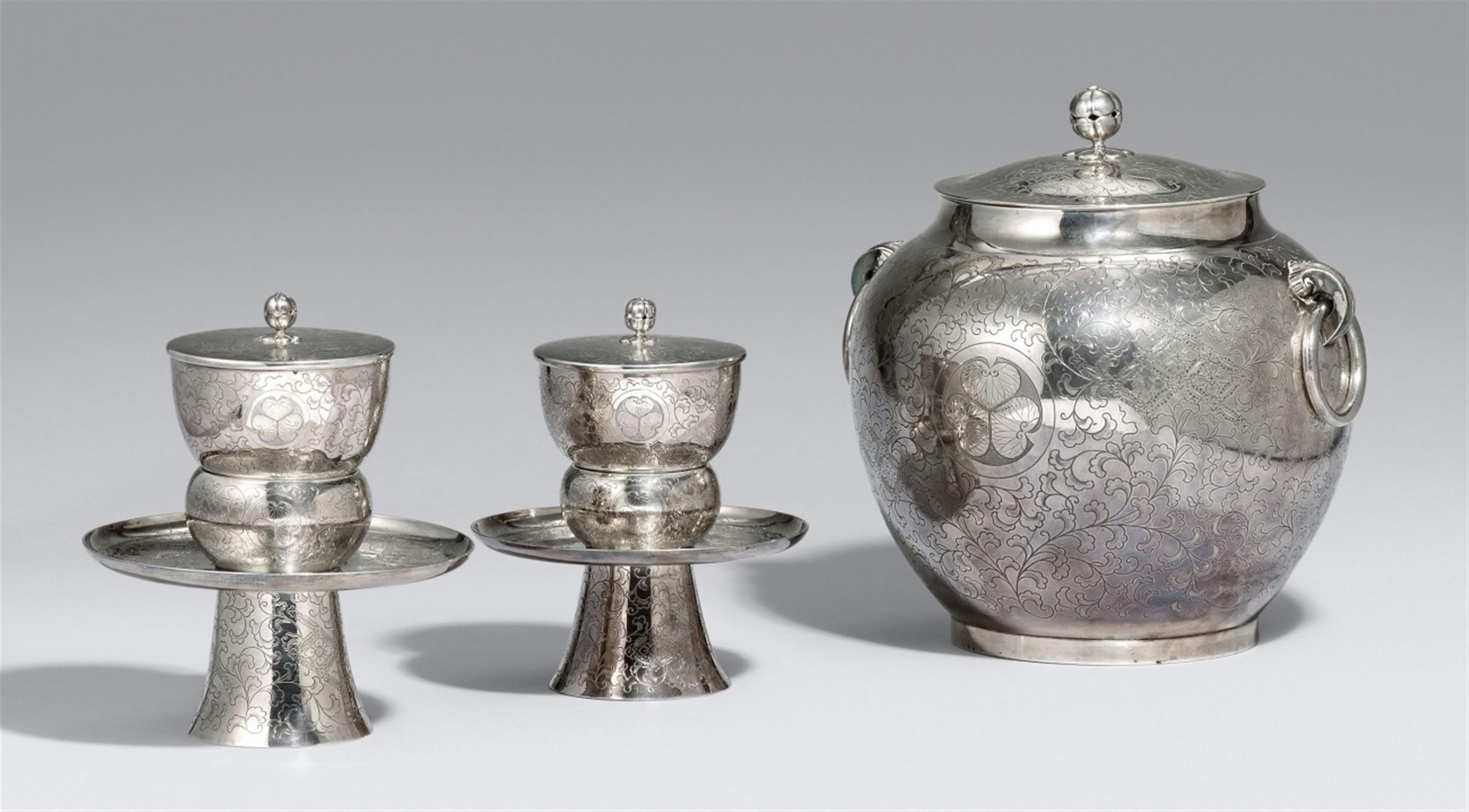 A silver lidded water jar (mizusashi) and two lidded tea cups with a stand. Early 20th century - image-1