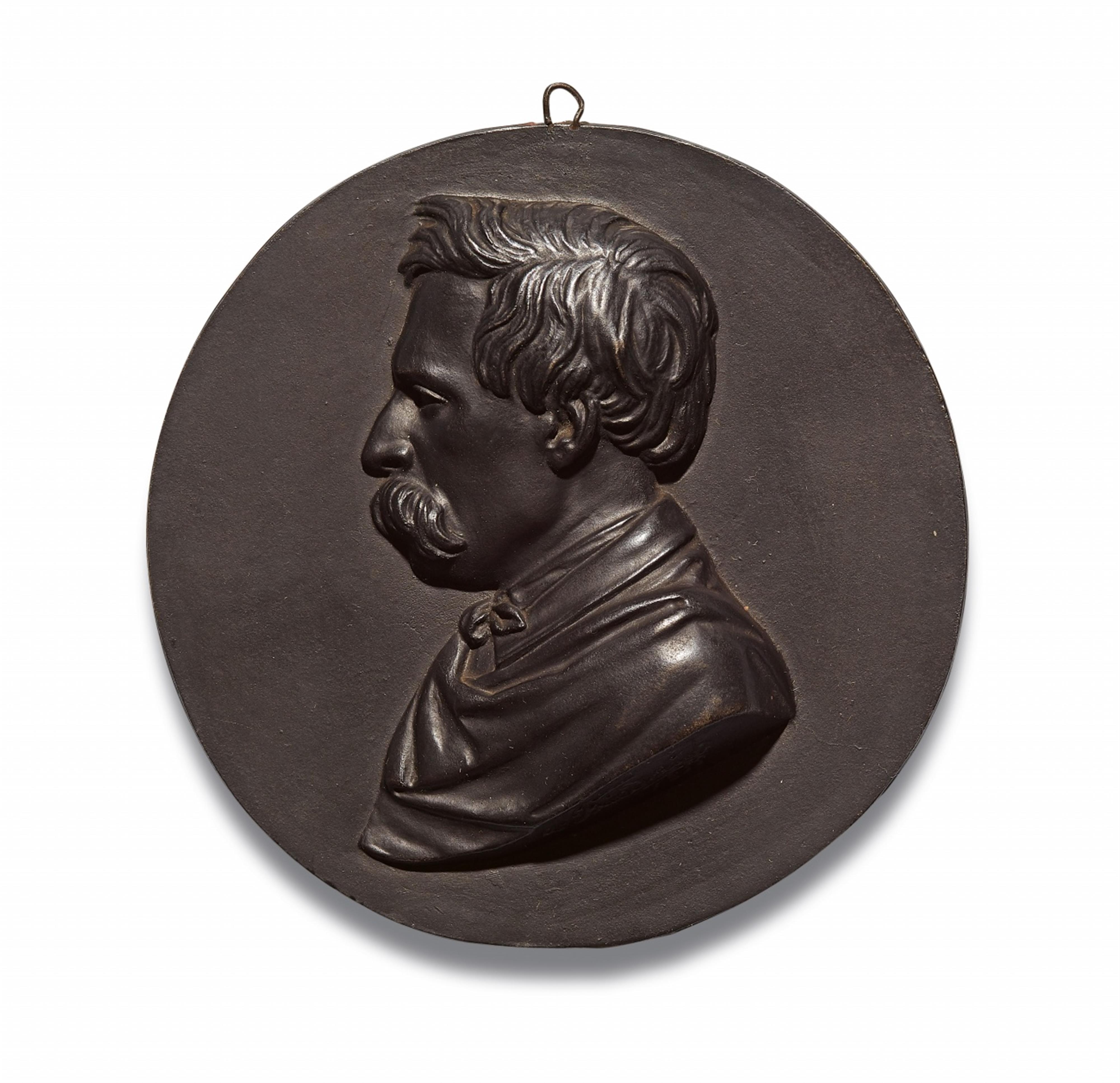 A cast iron medallion with a portrait of a bearded man - image-1