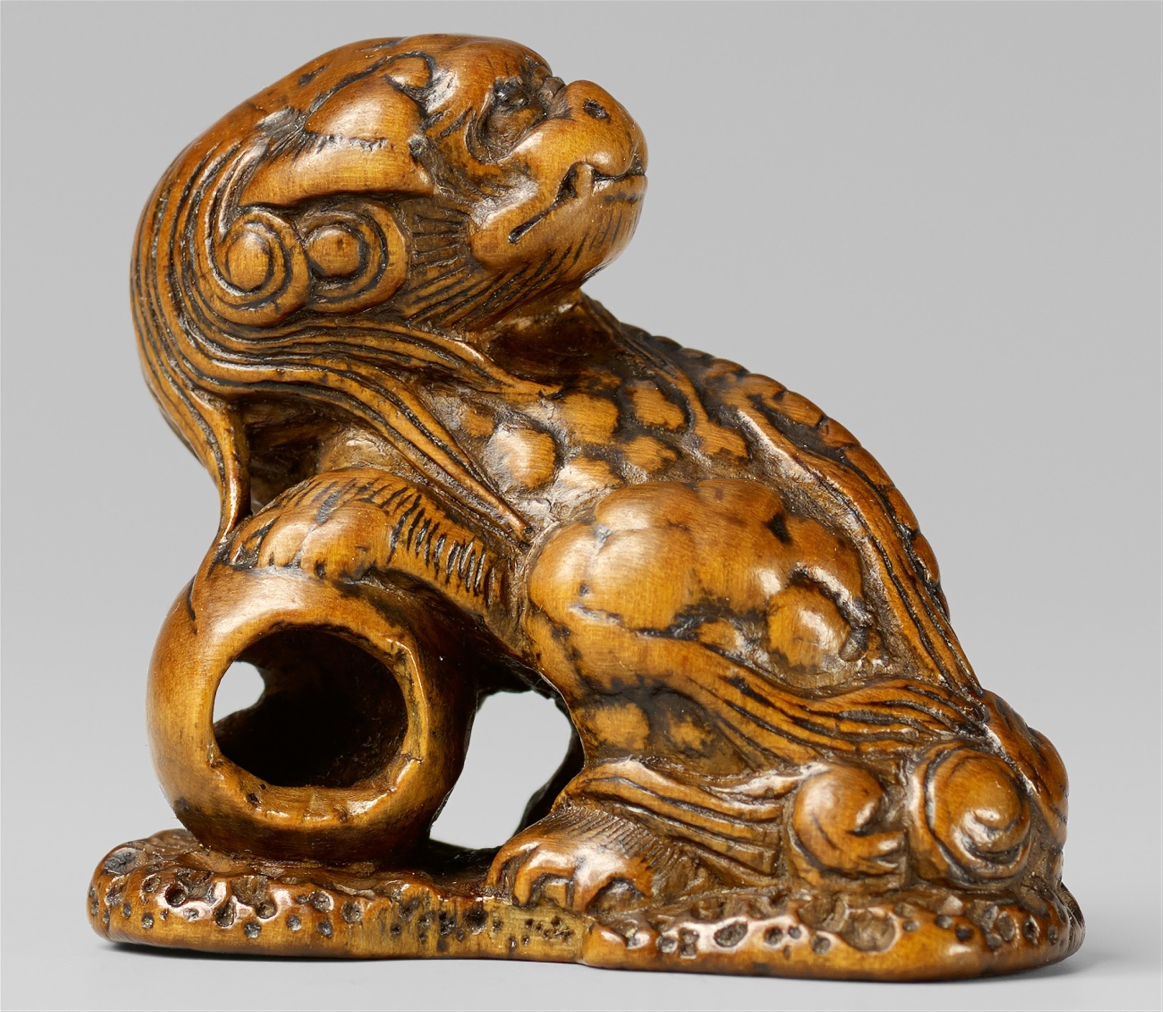 A boxwood netsuke of a shishi with a ball. Early 19th century - image-1