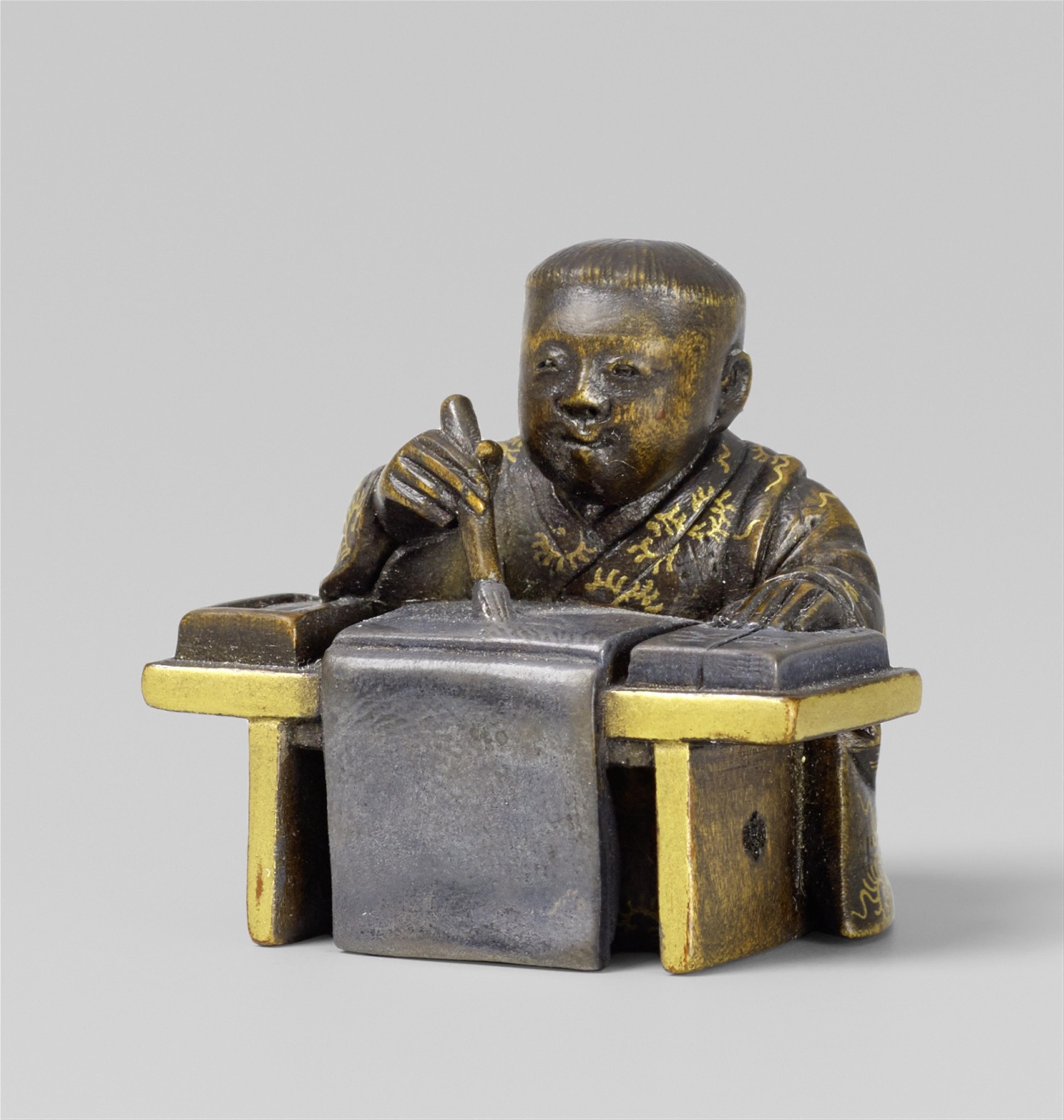 A partly lacquered wood netsuke of a boy writing. 2nd half 19th century - image-1