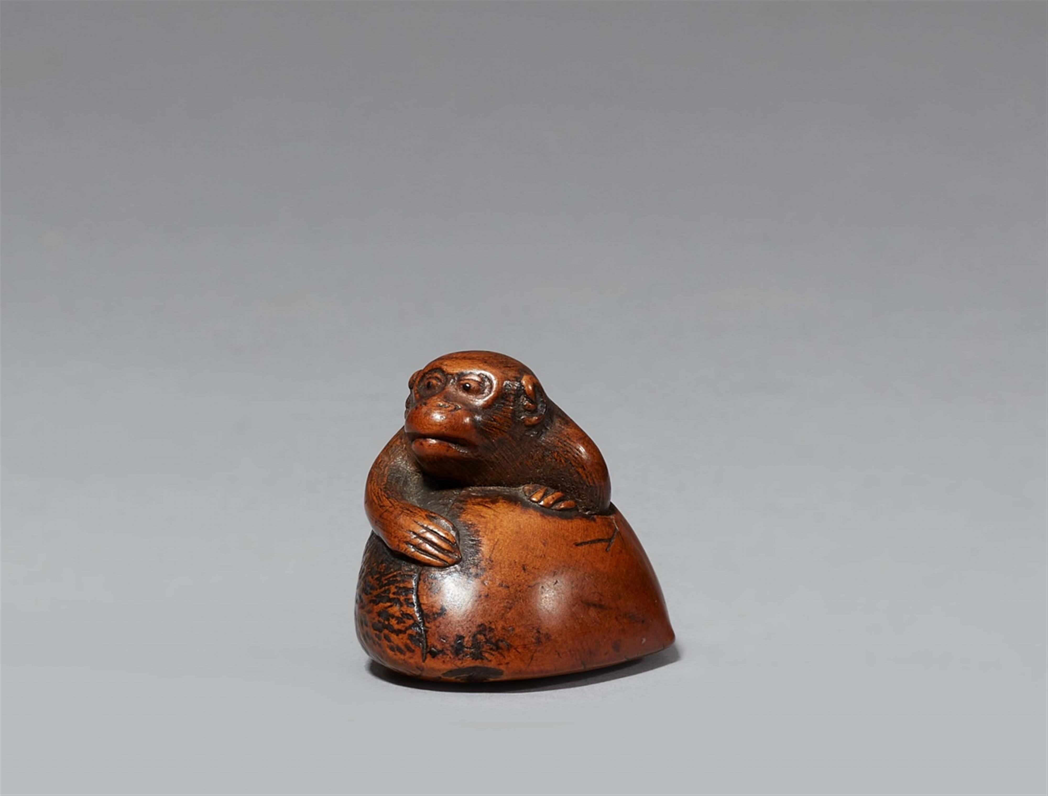 A boxwood netsuke of a monkey in a chestnut. Early 19th century - image-1