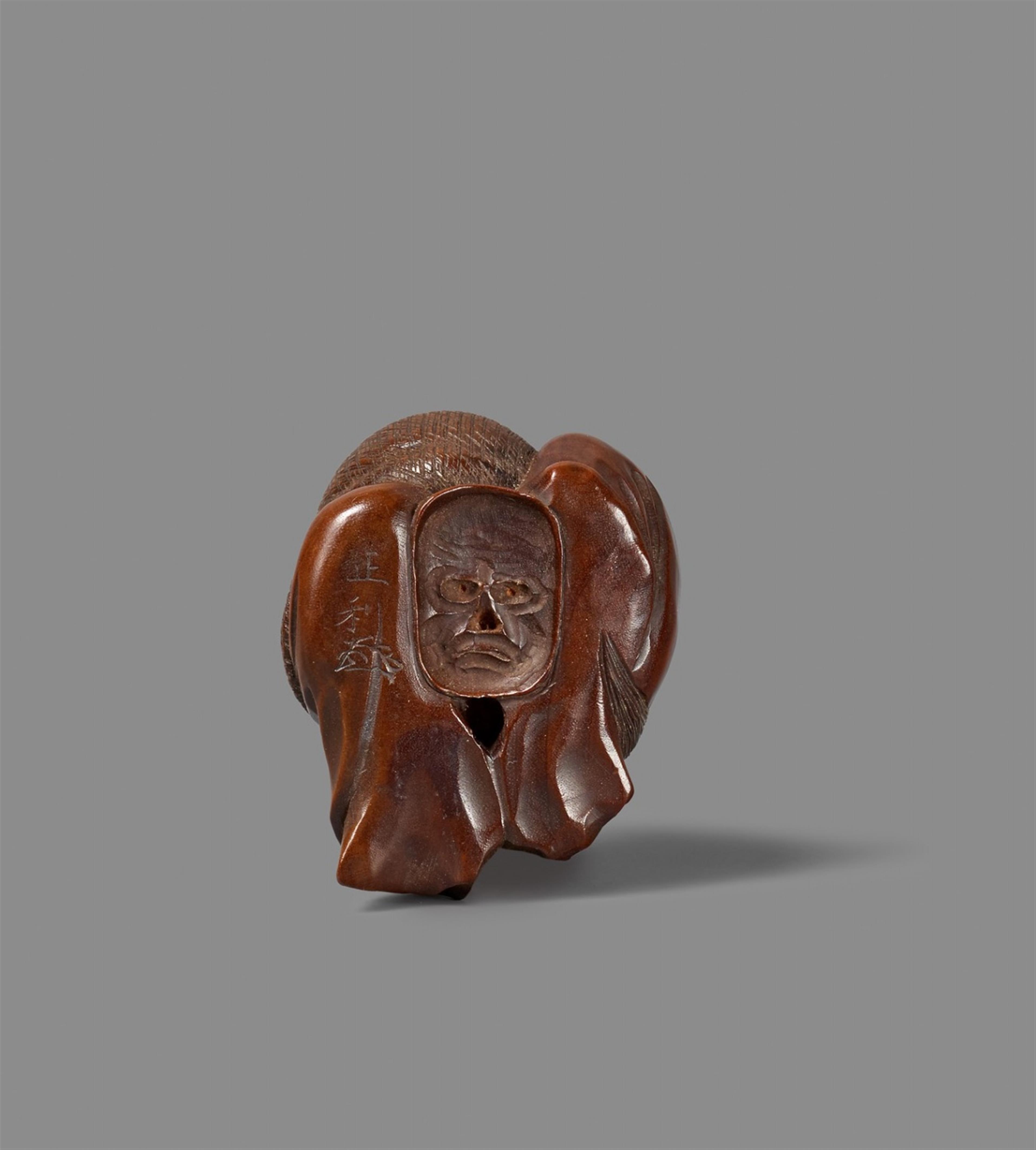 A Nagoya school fruitwood netsuke of Okame on a long-nosed mask, by Masatoshi. Mid-19th century - image-2