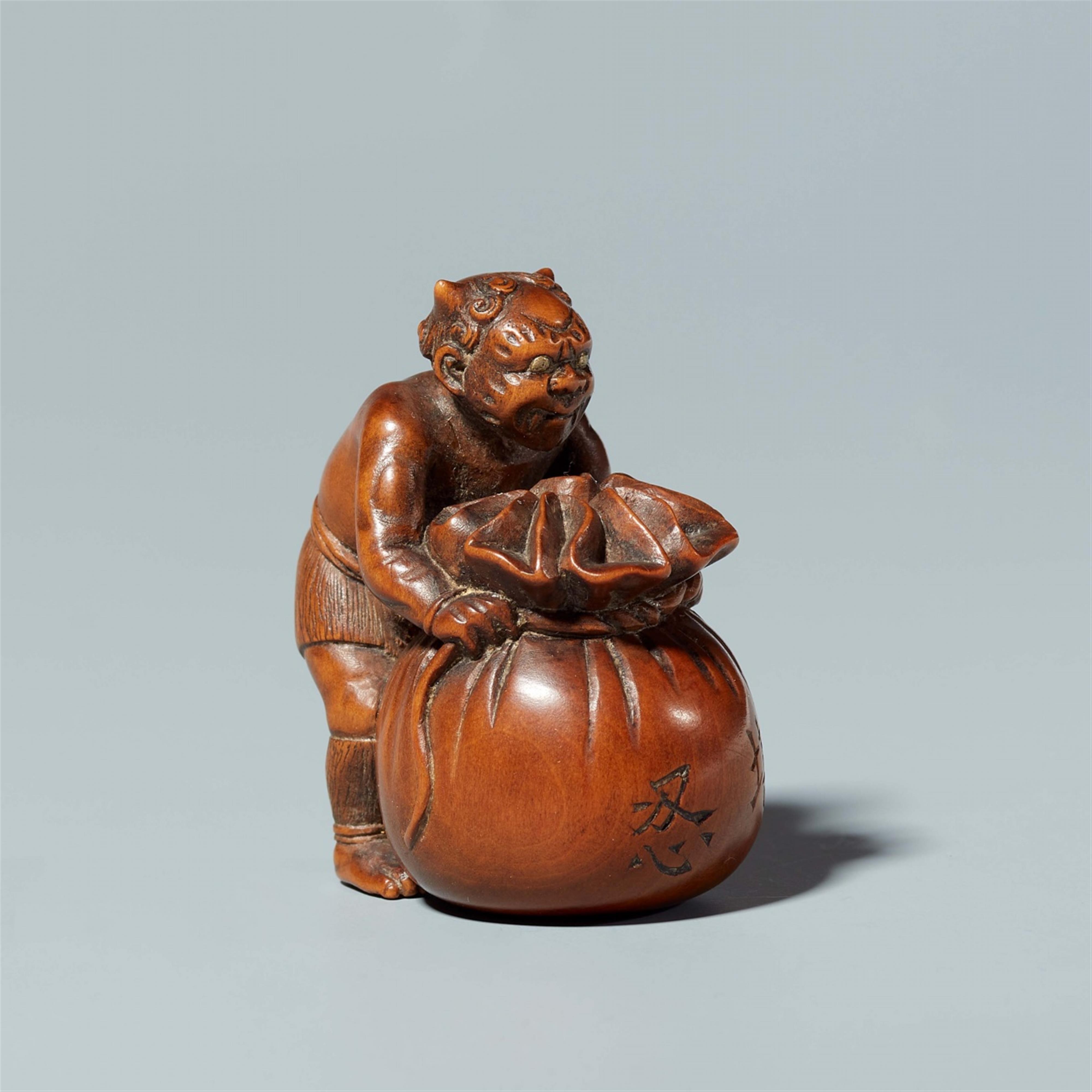 A boxwood netsuke of oni with a sack, by Minsai. Around 1830 - image-1