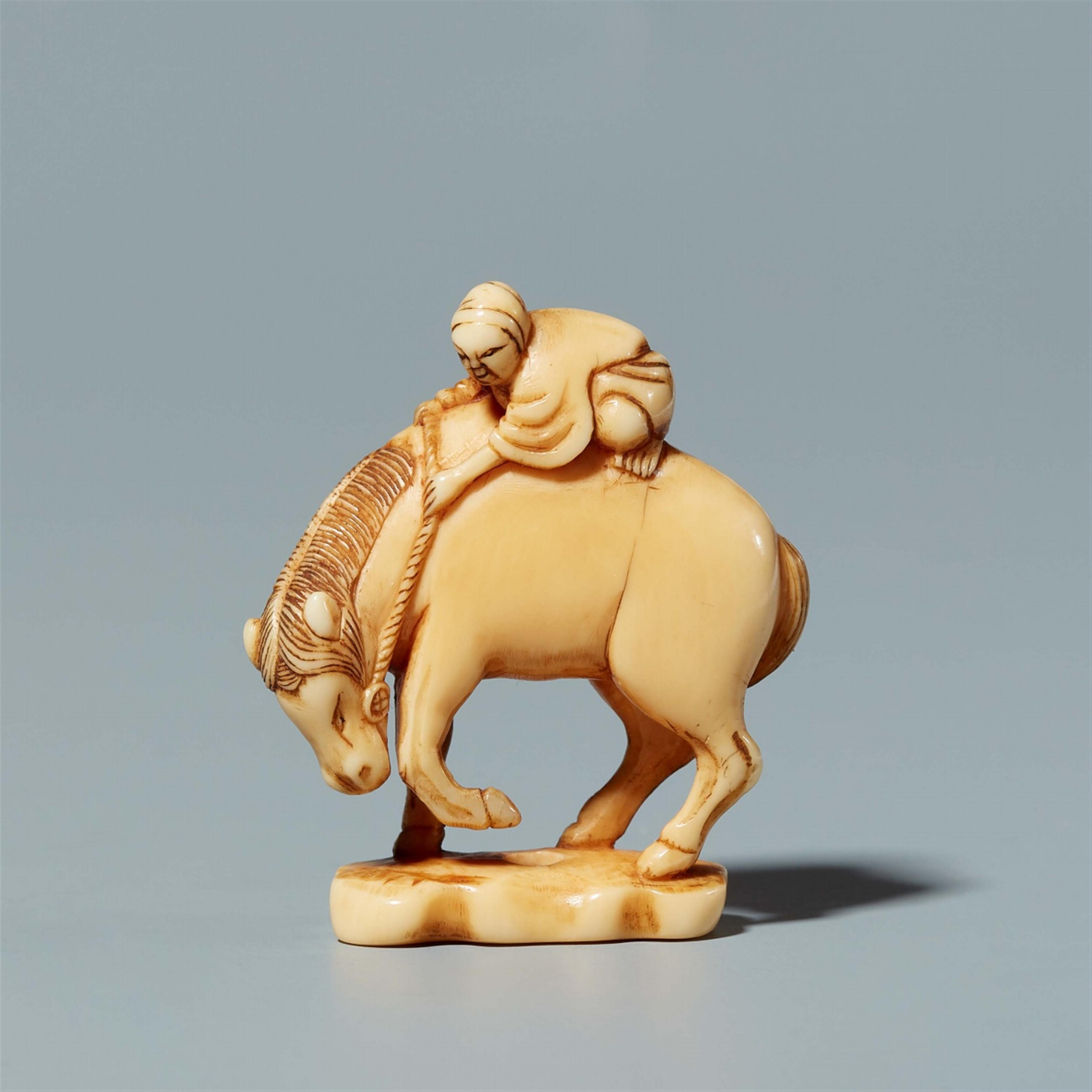 An ivory okimono netsuke of a servant on a horse. Second half 19th century - image-1