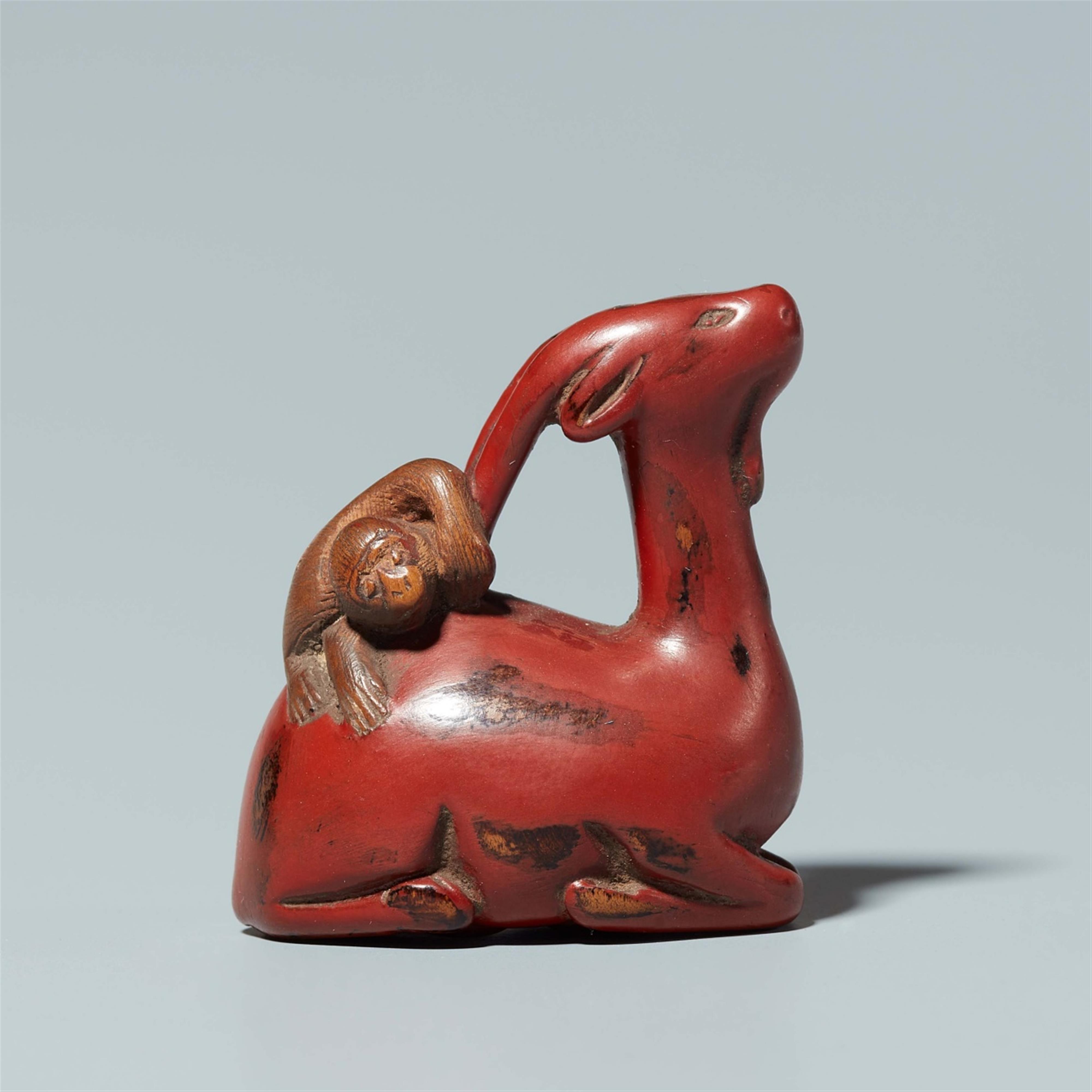 A lacquer on wood netsuke of a monkey on a deer. 18th century - image-1