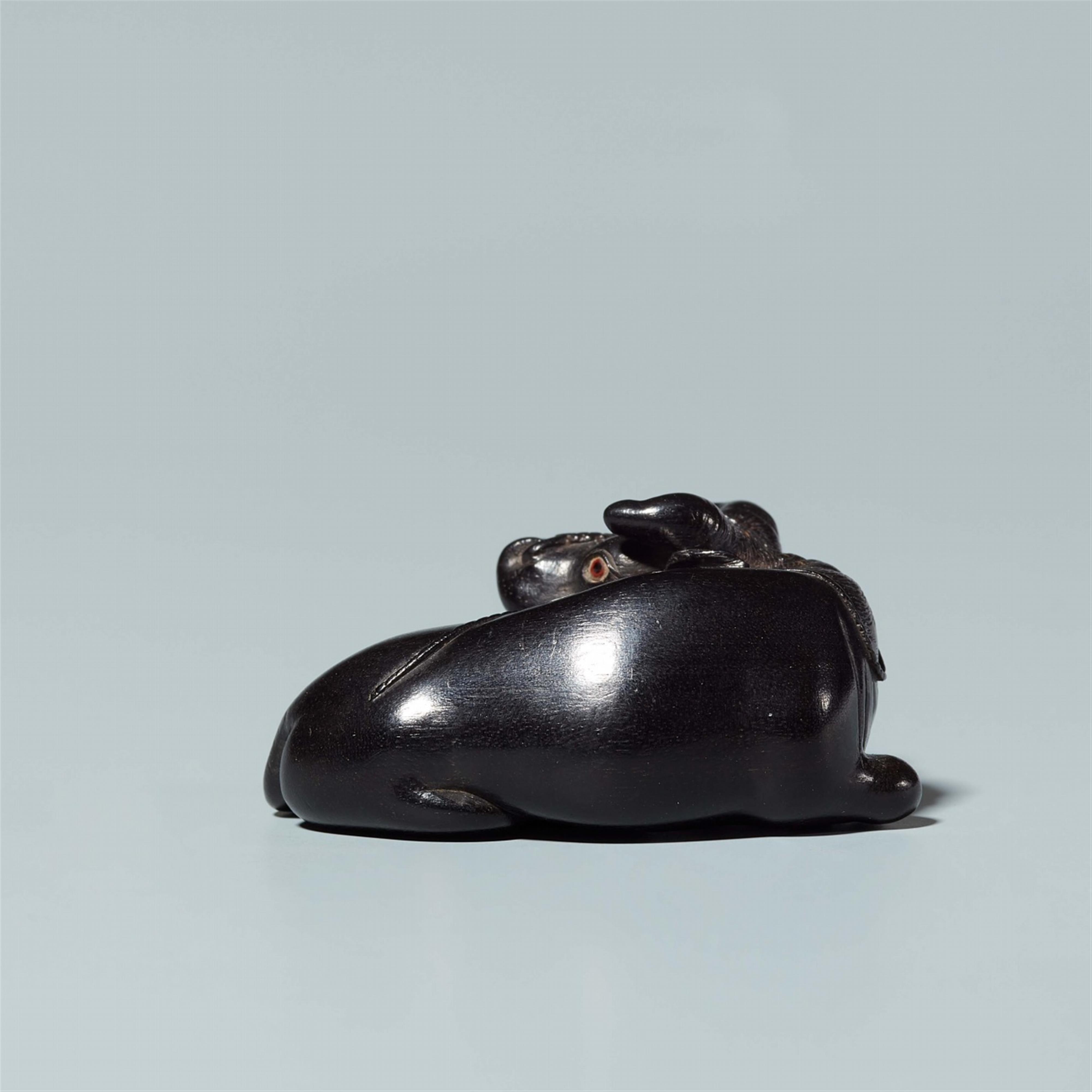 An ebony netsuke of a reclining ox, by Sekiran. Late 19th century - image-2