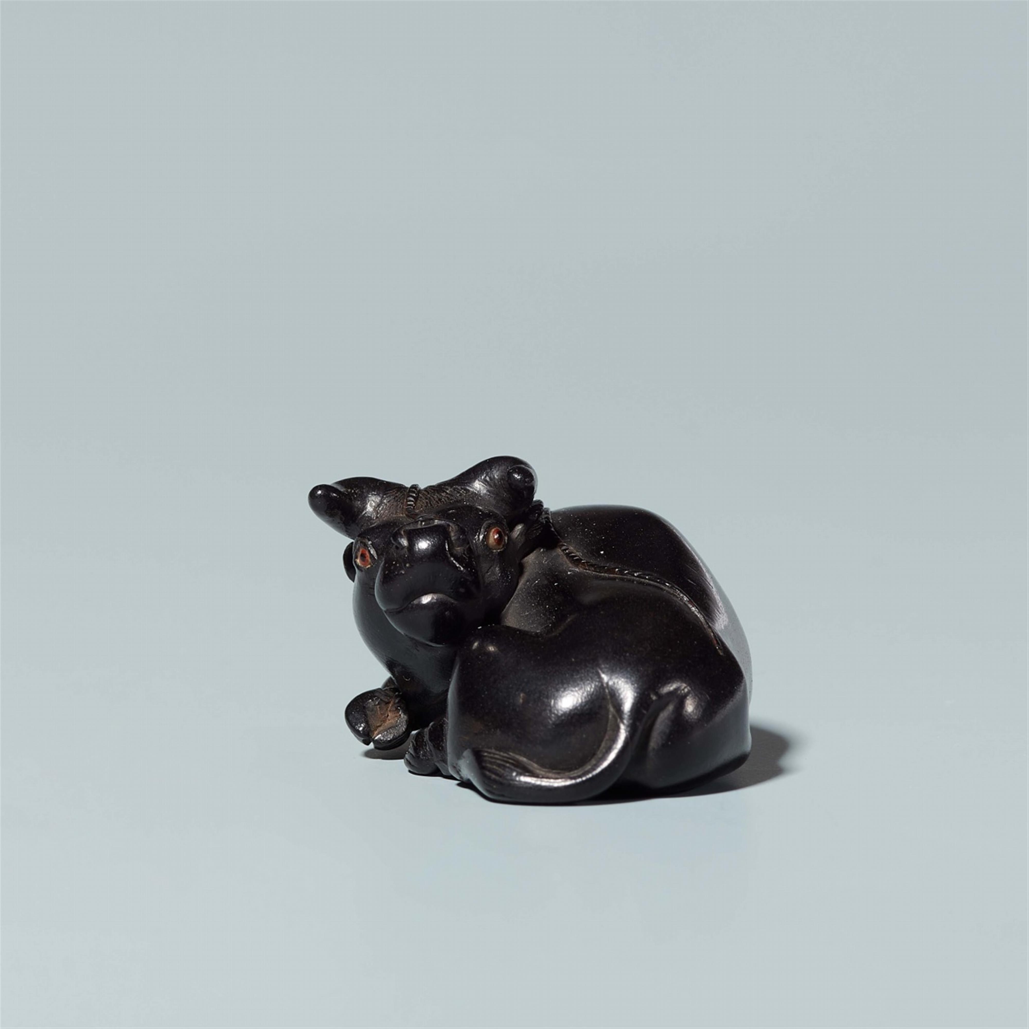 An ebony netsuke of a reclining ox, by Sekiran. Late 19th century - image-3