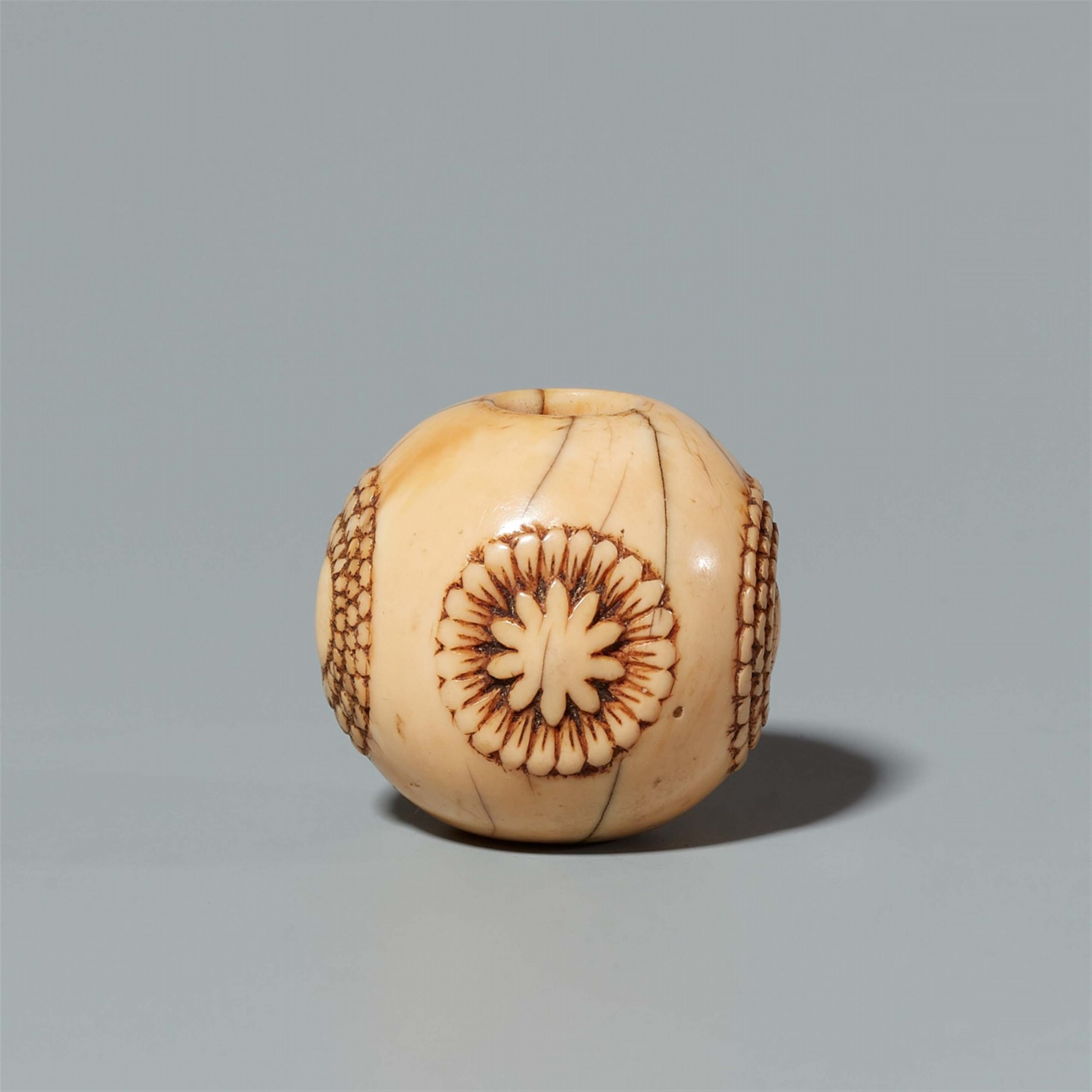 An ivory netsuke of a sphere with stylised blossoms. Late 19th century - image-1
