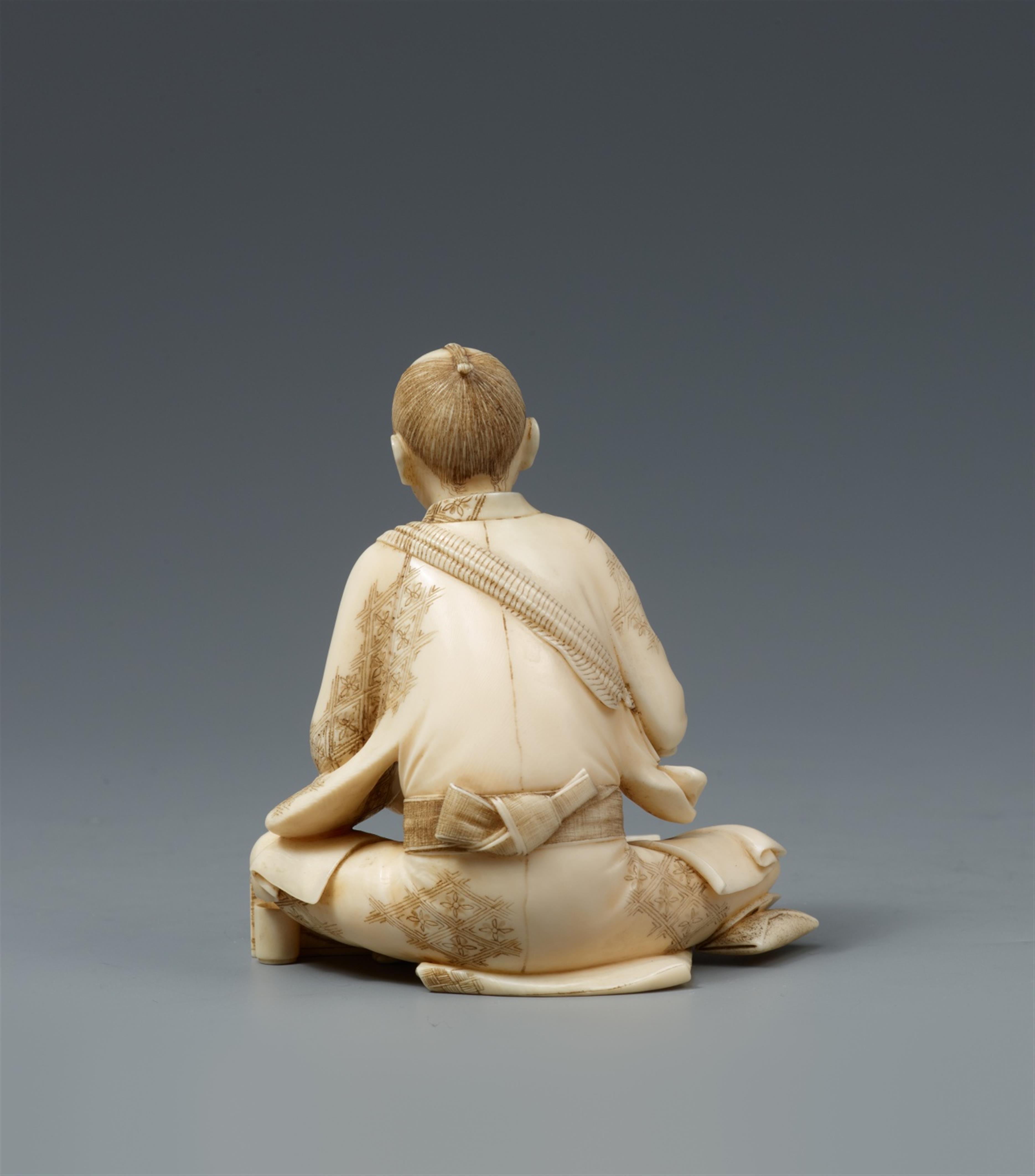 An ivory okimono of a man grinding small leaves. Late 19th century - image-2