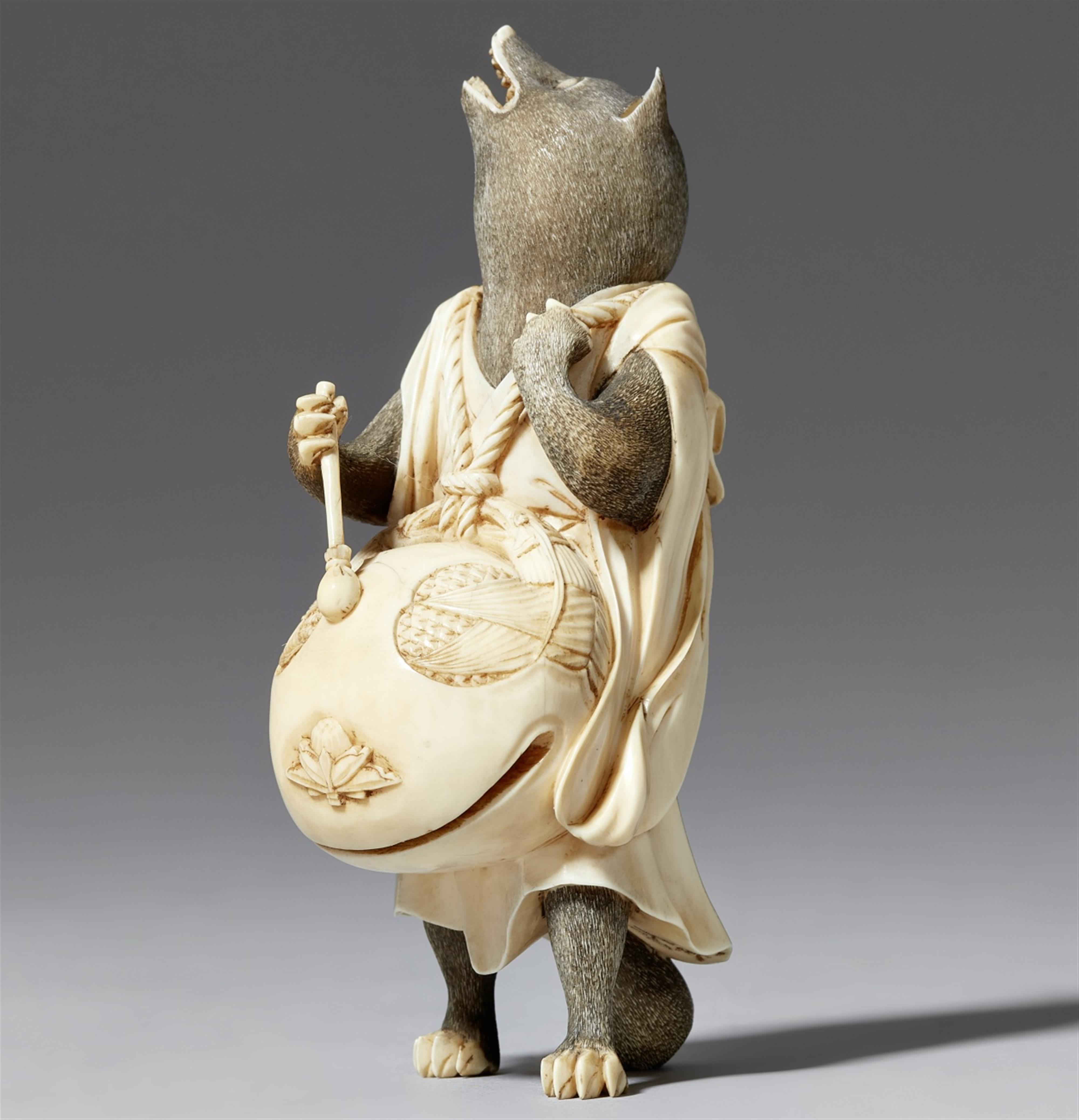 A ivory okimono of a tanuki with a mokugyo. Late 19th century - image-1