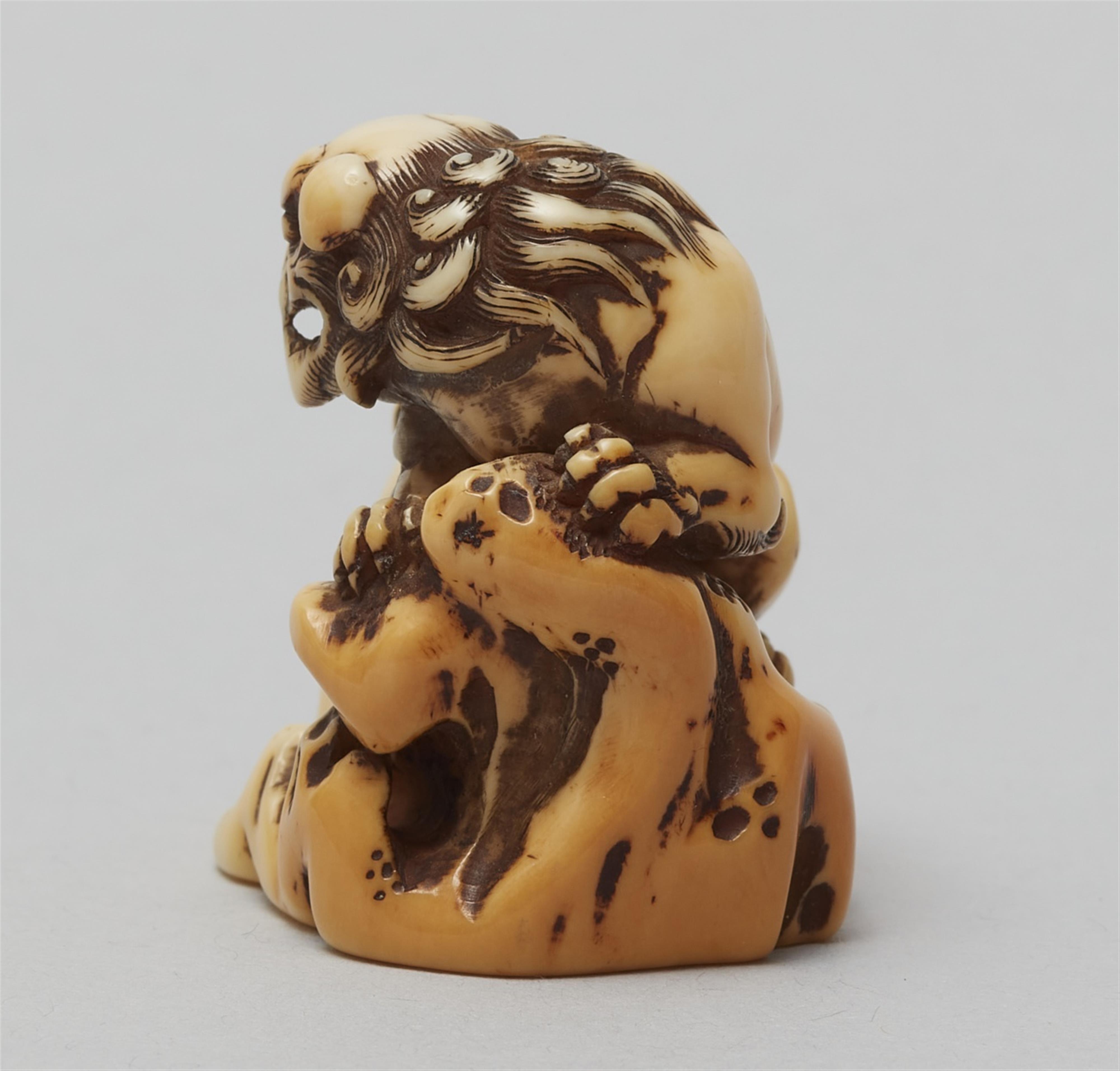 An ivory netsuke of a shishi by a rock. Late 18th century - image-4