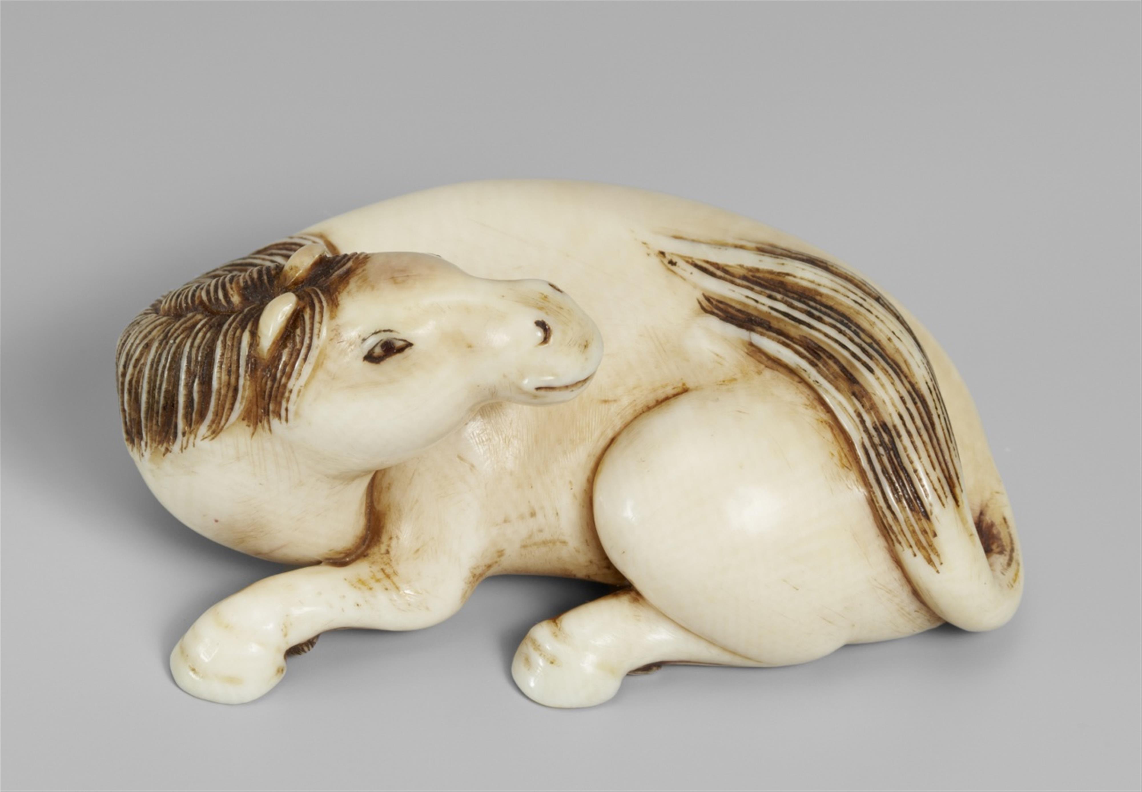 An ivory netsuke of a recumbent stallion. 19th century - image-1