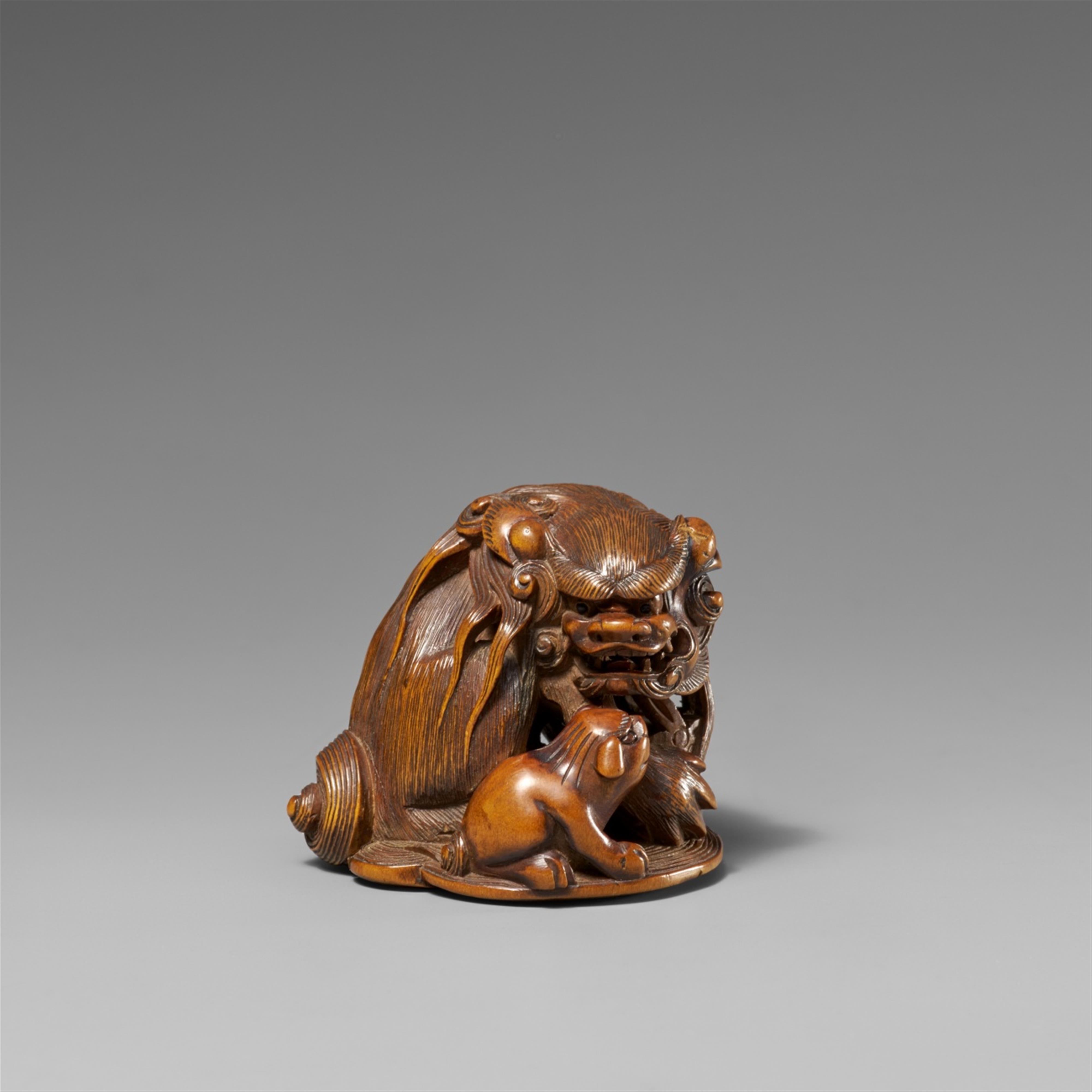 A boxwood netsuke of a shishi with cub. 19th century - image-1