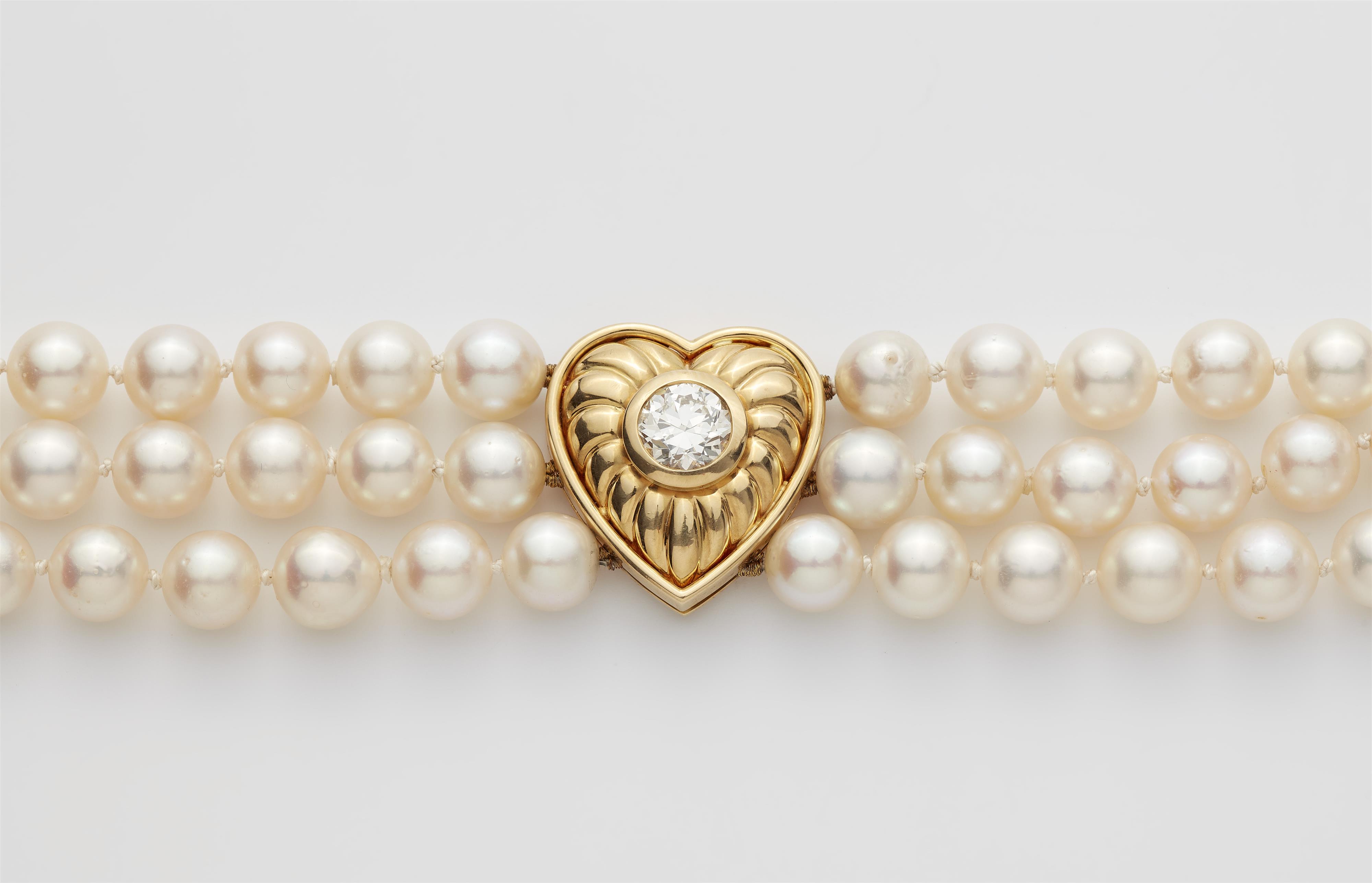 A cultured pearl necklace with an 18k gold heart set with a diamond solitaire. - image-2
