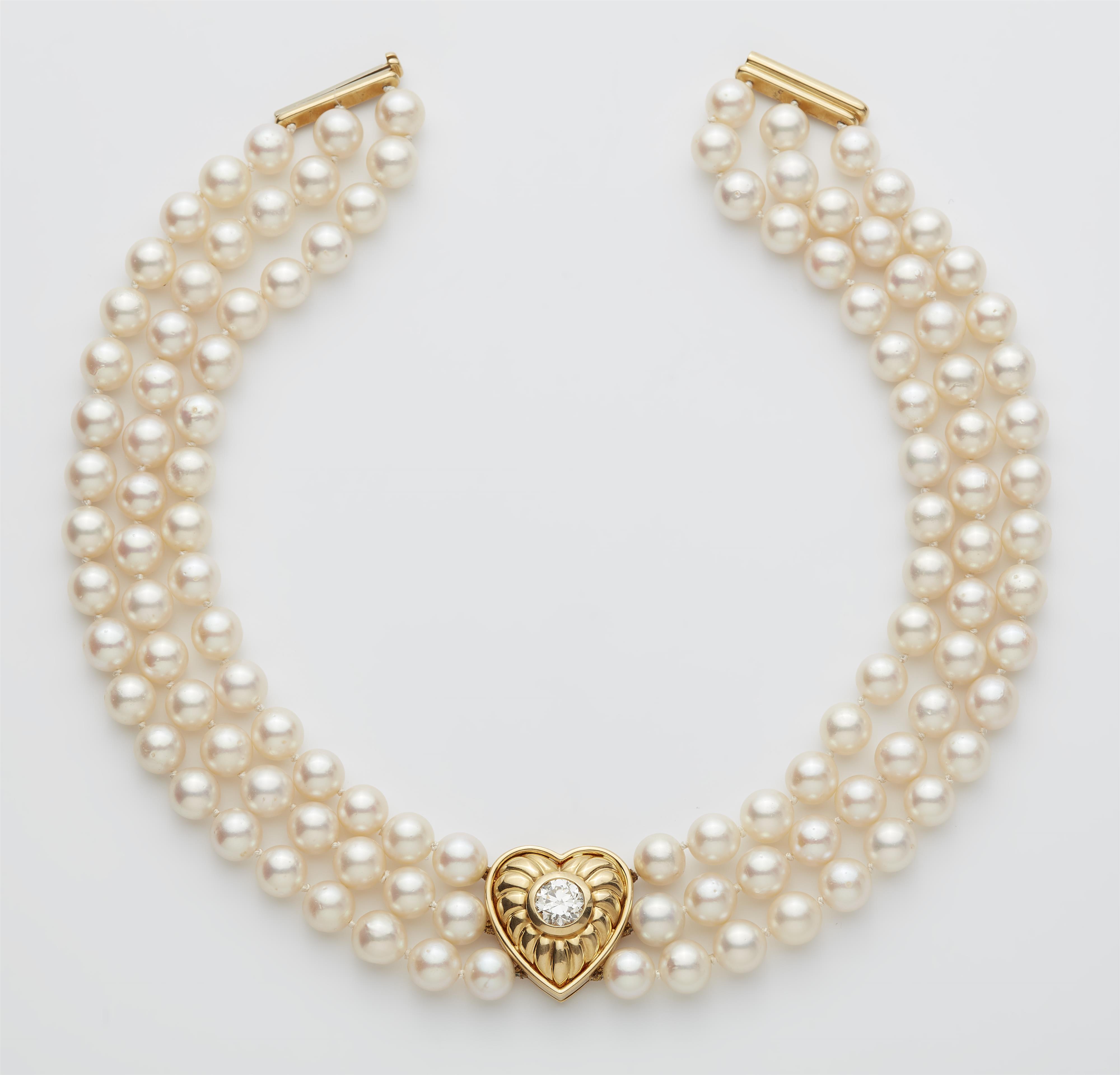 A cultured pearl necklace with an 18k gold heart set with a diamond solitaire. - image-1