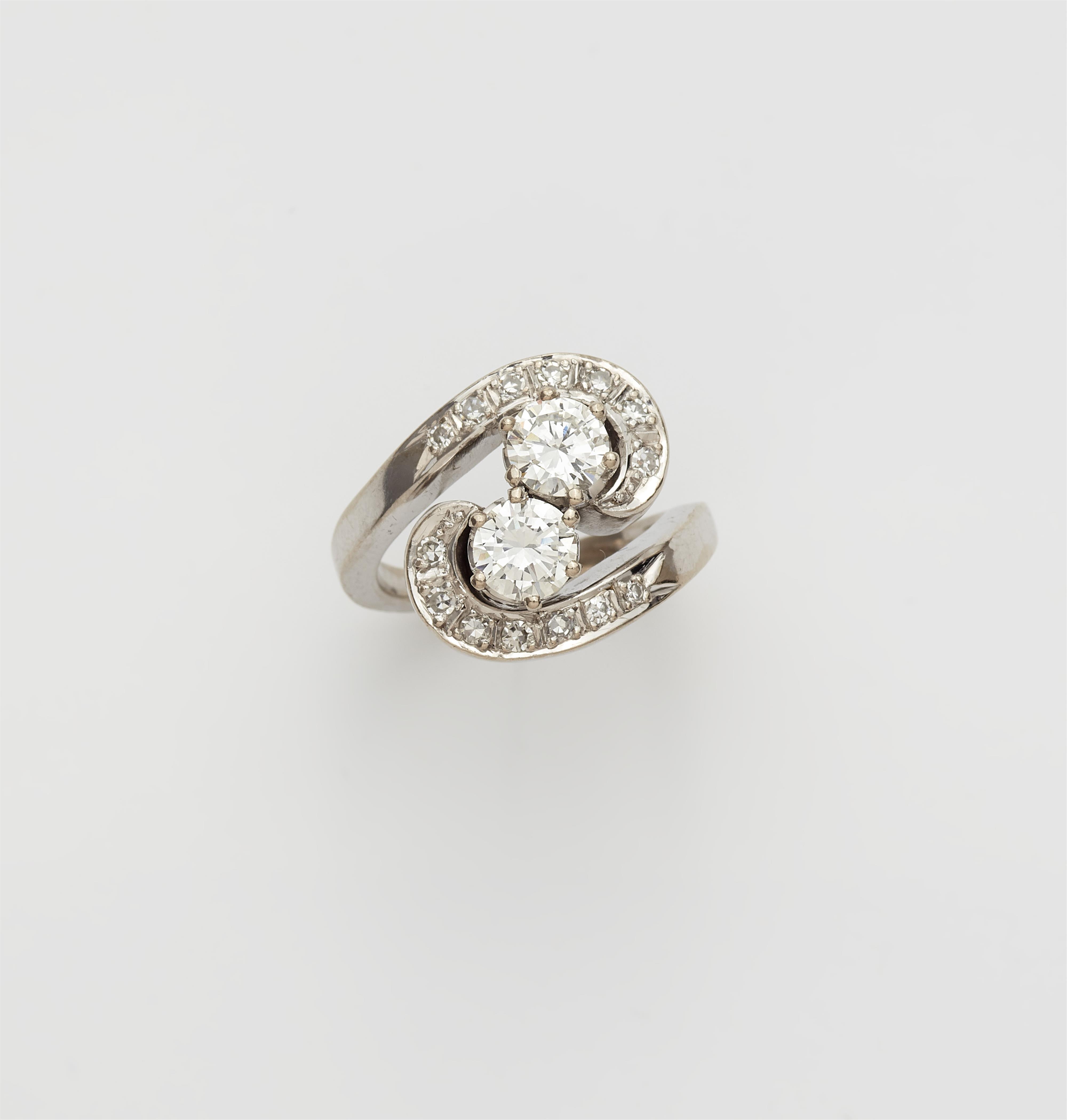 A 14k white gold diamond crossover ring with two brilliant-cut diamond solitaires. - image-1