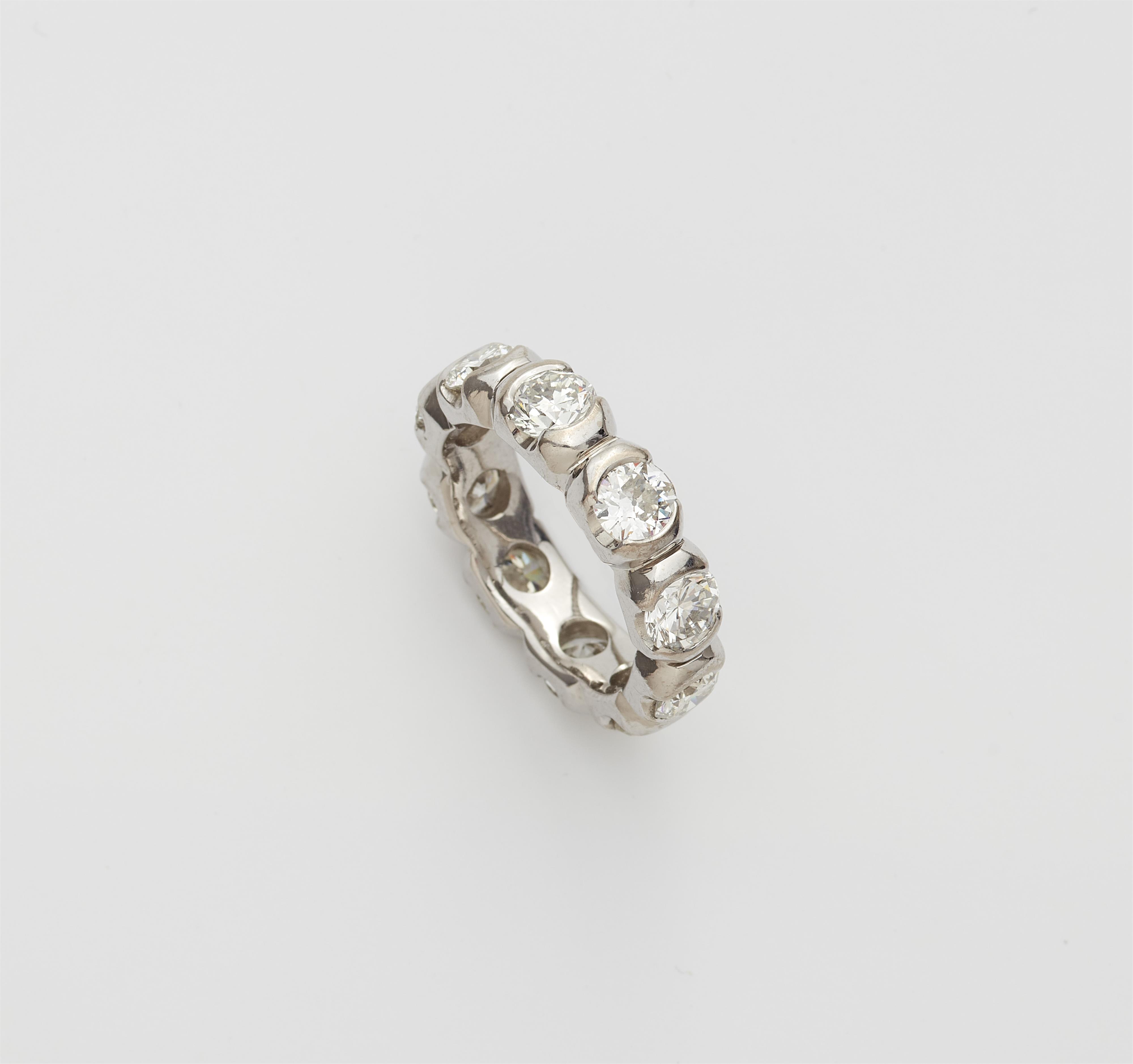An 18k white gold and diamond eternity ring. - image-1