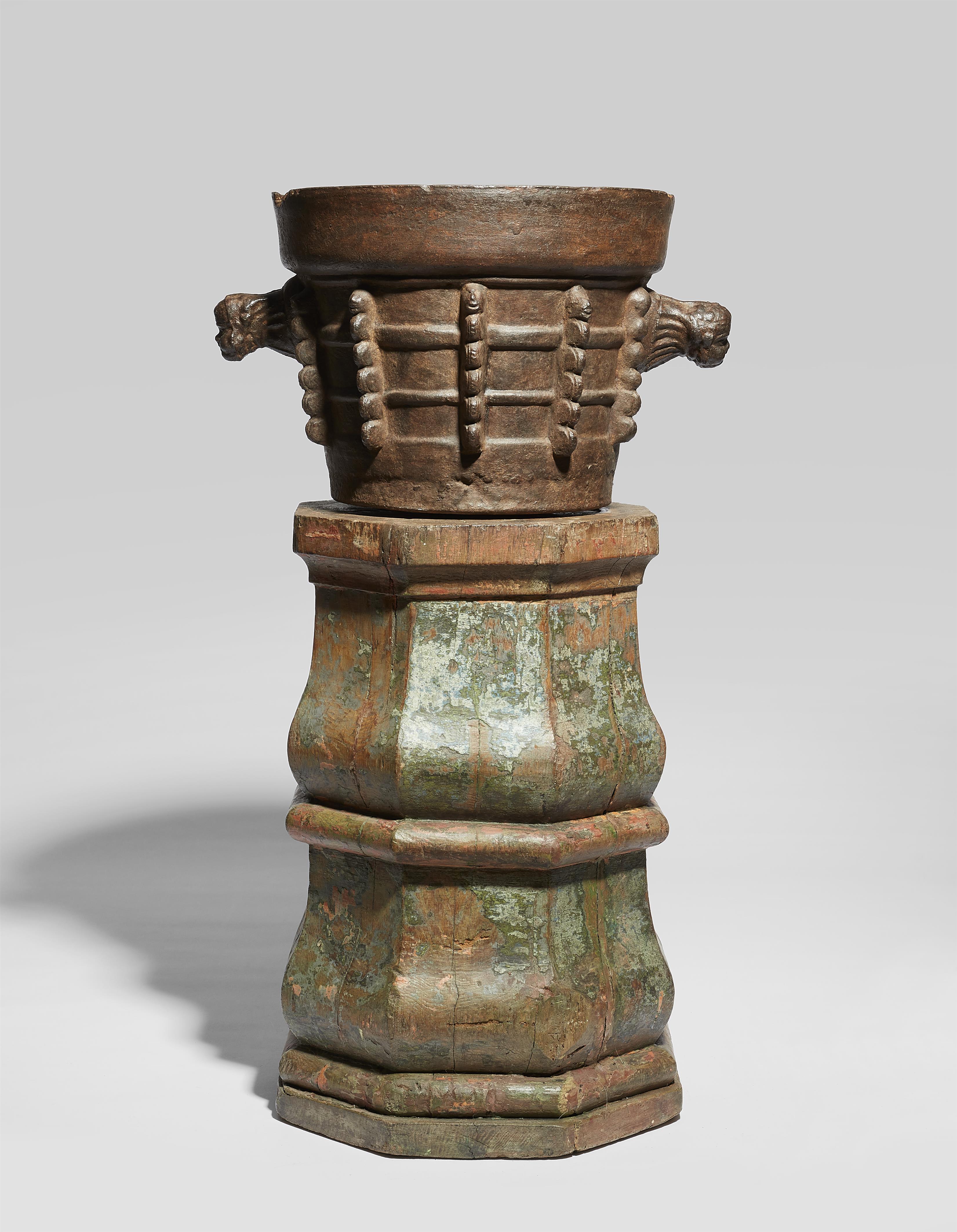 A large Gothic iron mortar on a wooden plinth - image-1