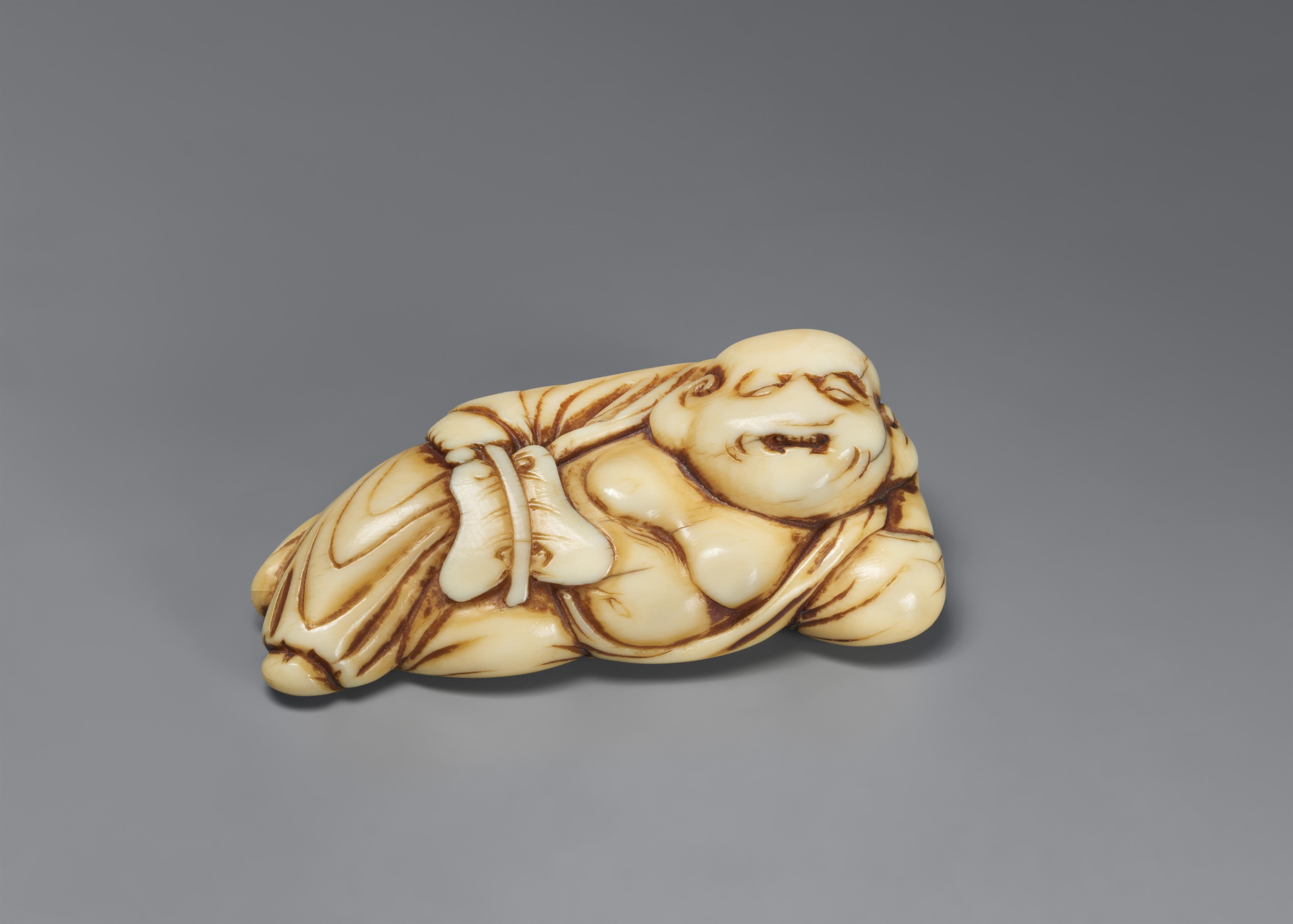 An ivory netsuke of a reclining Hotei. 18th century - image-1