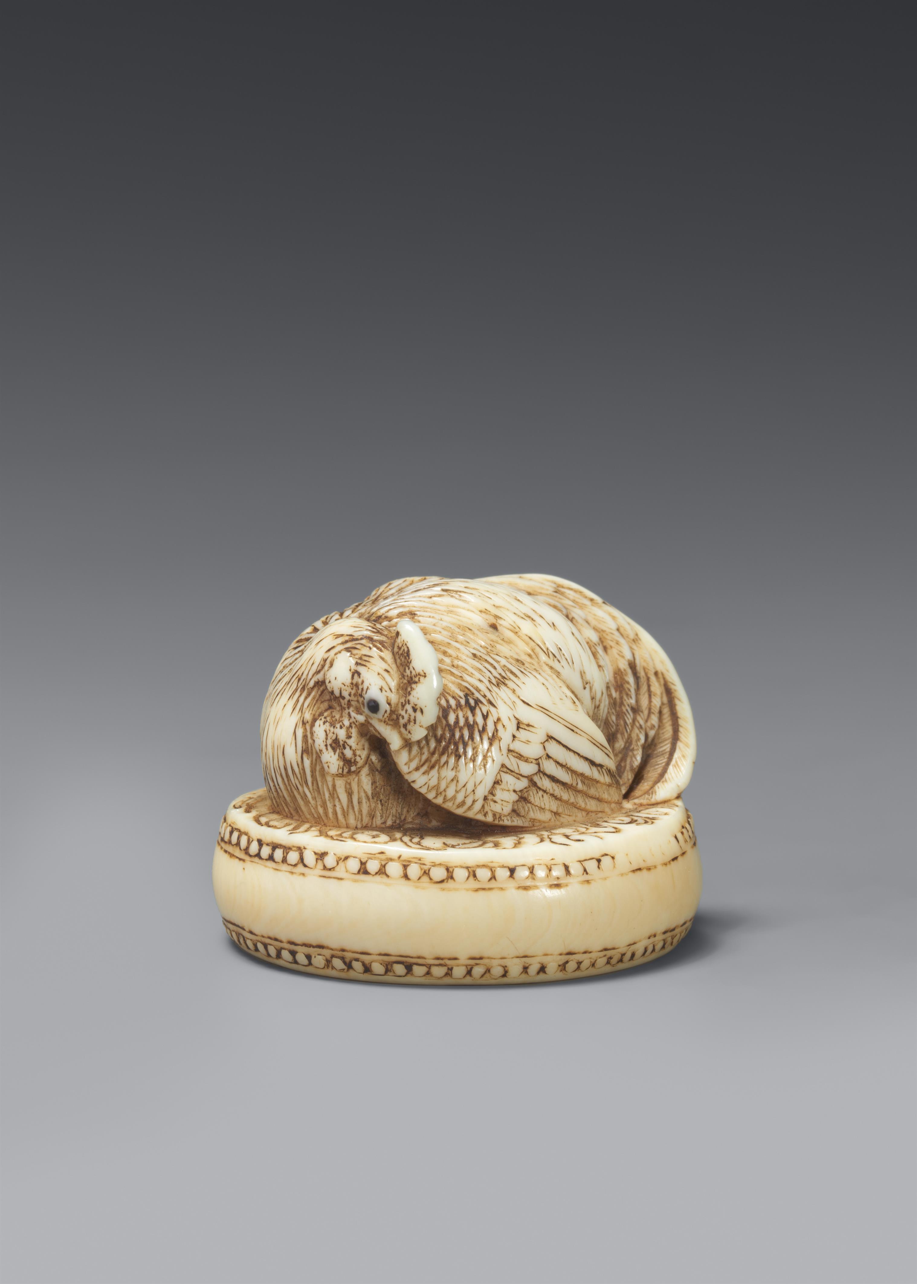 An ivory netsuke of a rooster sitting on a drum. 19th century - image-1