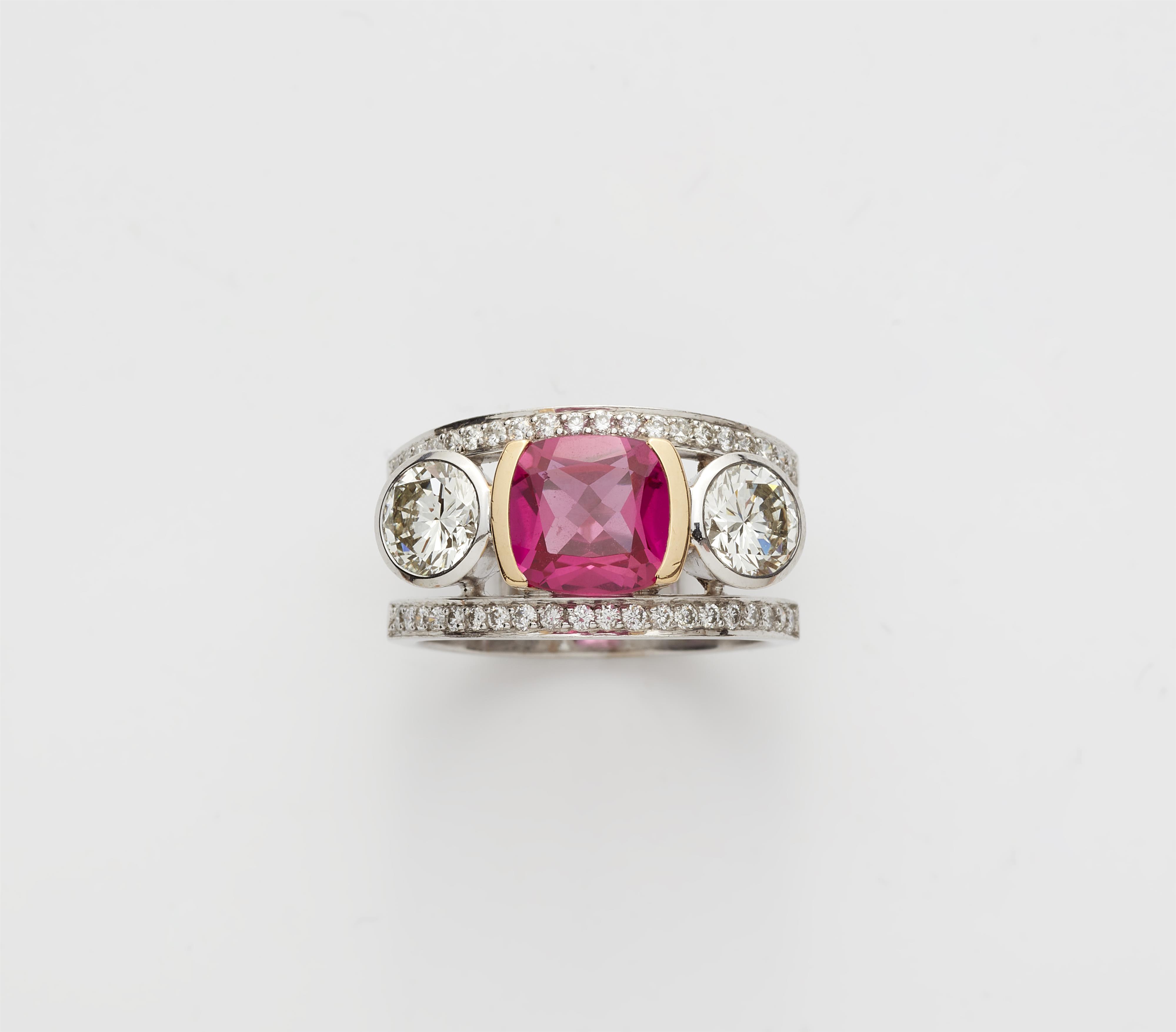 An 18k white gold diamond and synthetic pink sapphire three stone ring. - image-1