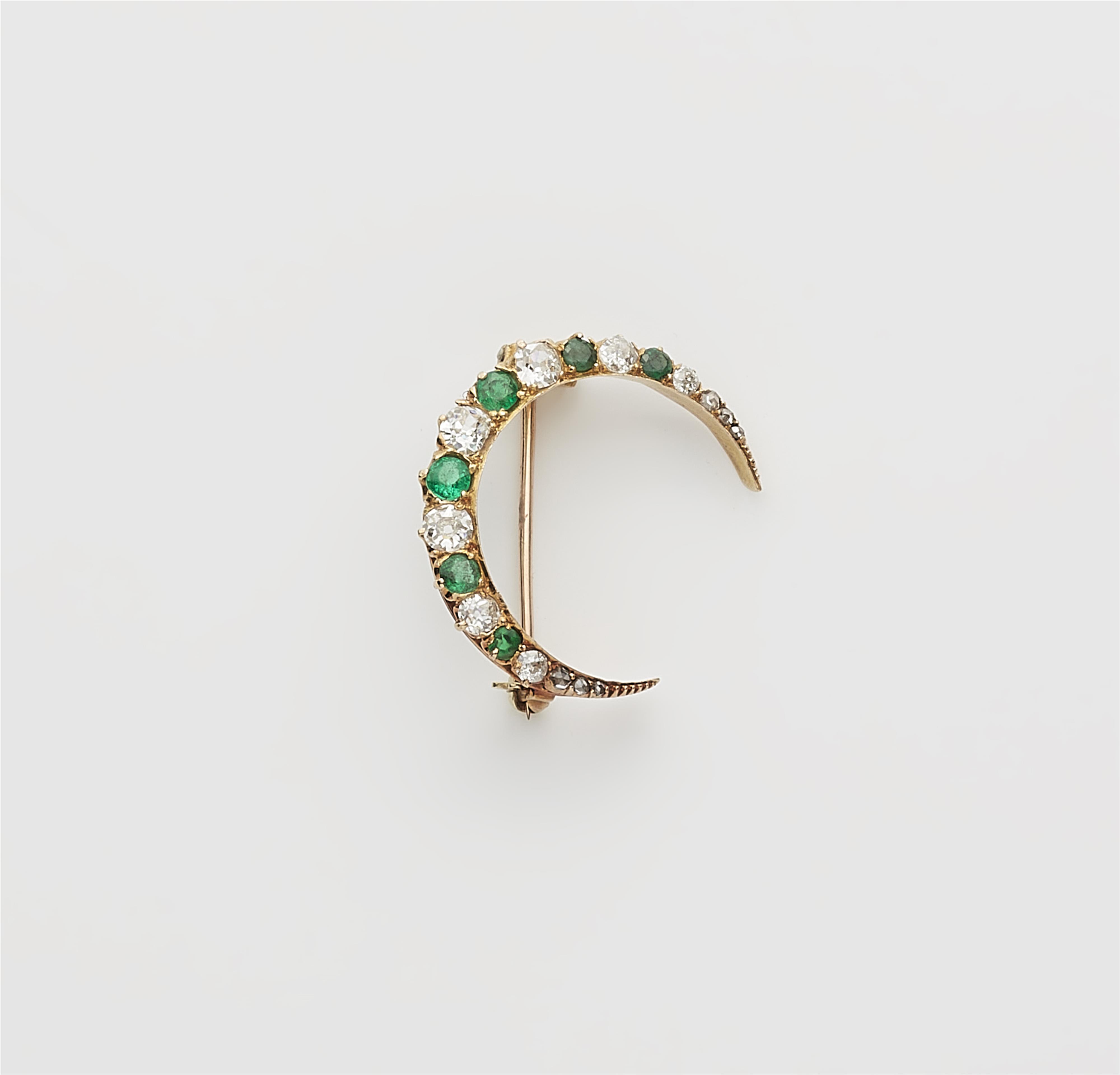 A 14k gold diamond and emerald crescent moon brooch. - image-1