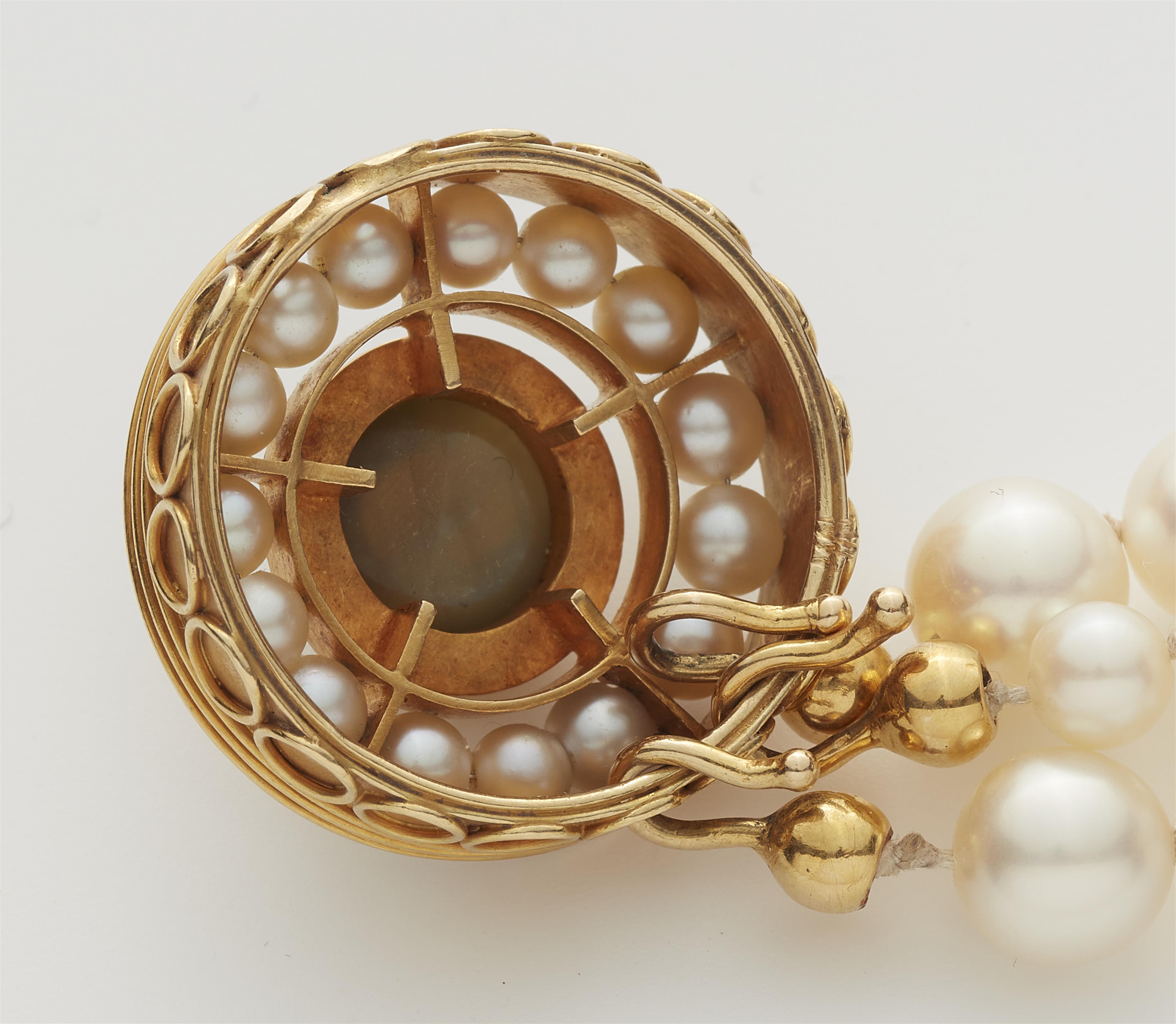 A German three stranded cultured pearl necklace with a circular 18k gold pearl and chrysoberyl cabochon clasp. - image-2