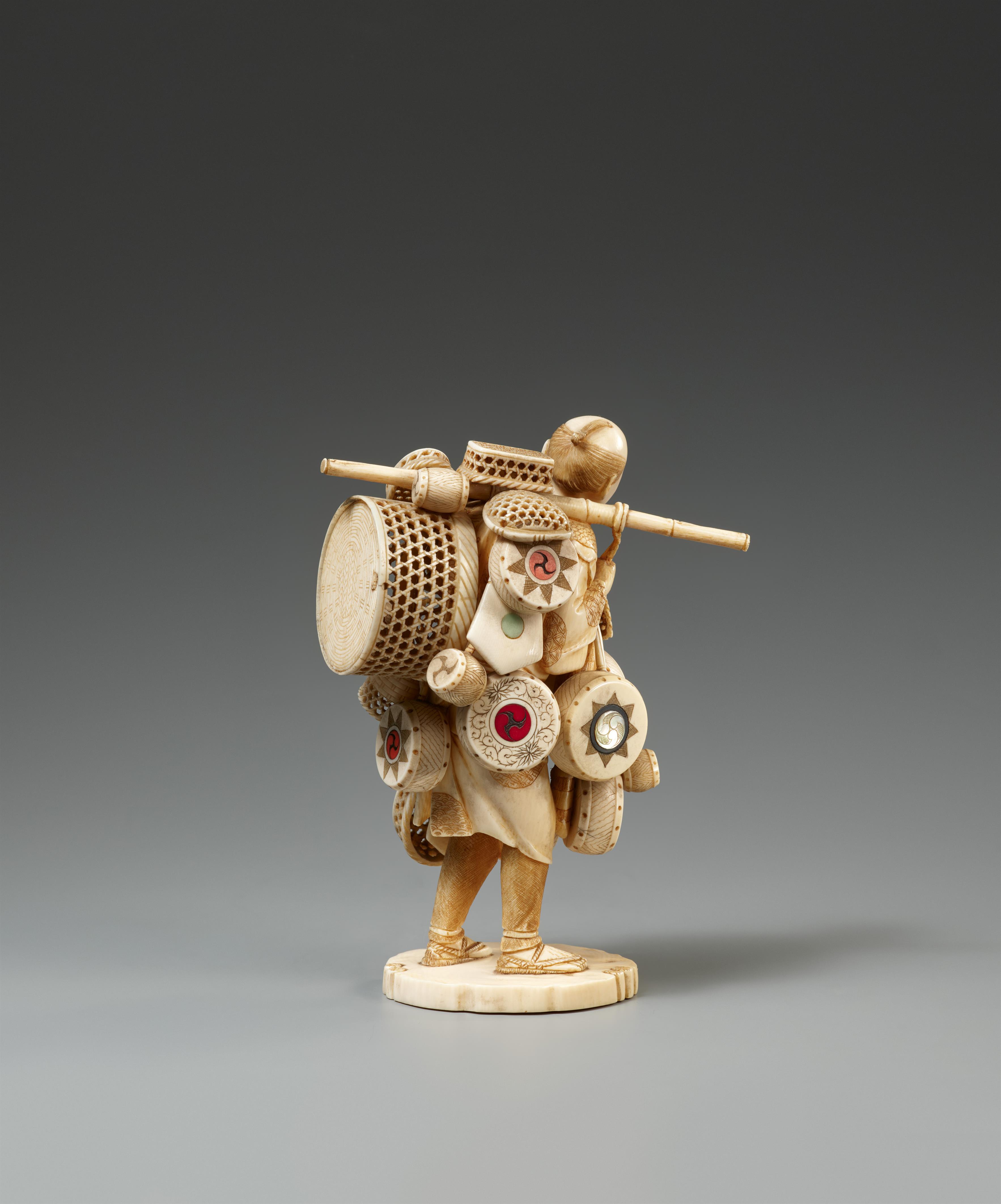 A sectional ivory okimono of a basket and drum seller. Around 1900 - image-2