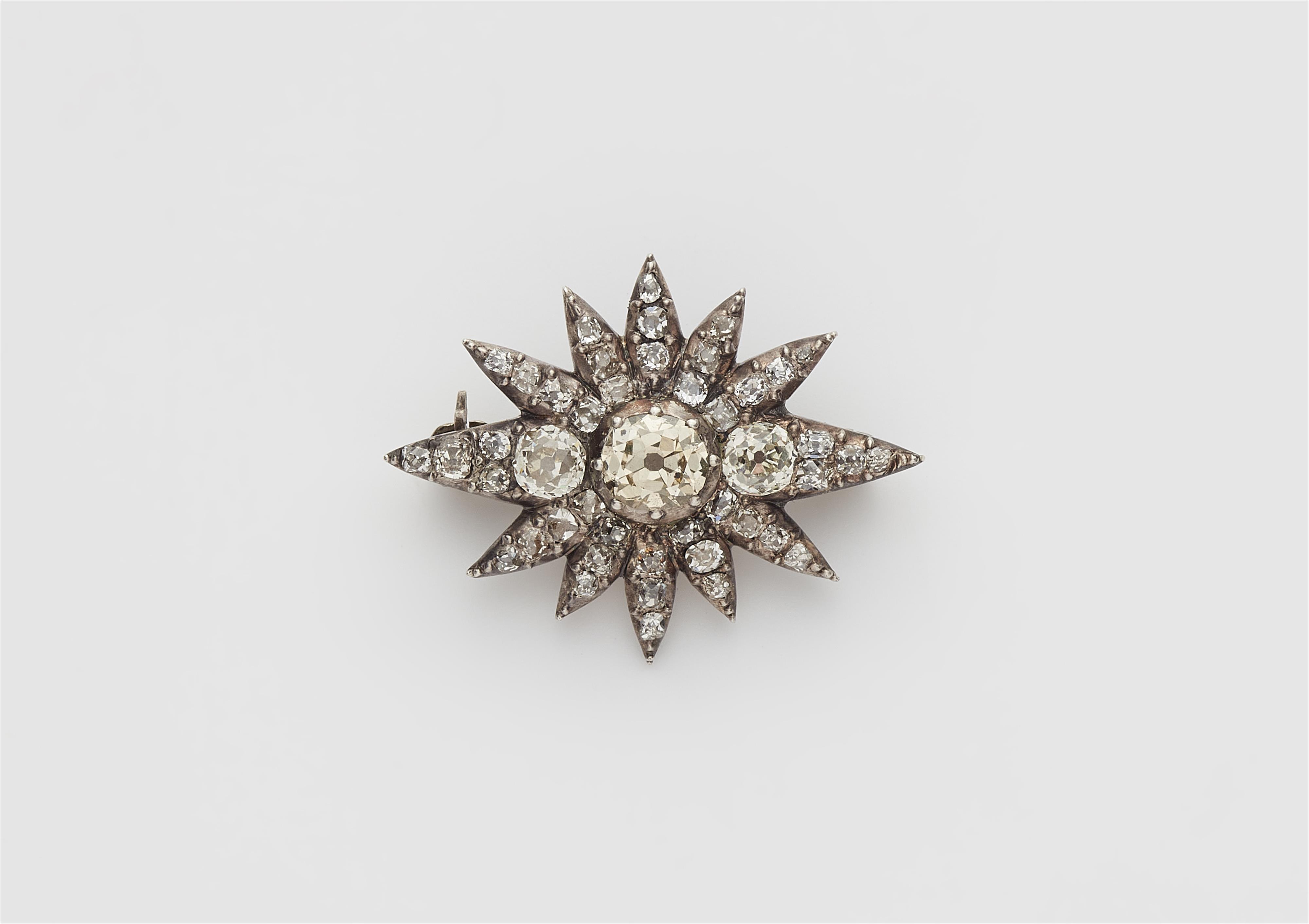 A small silver and cushion-cut diamond star brooch. - image-1