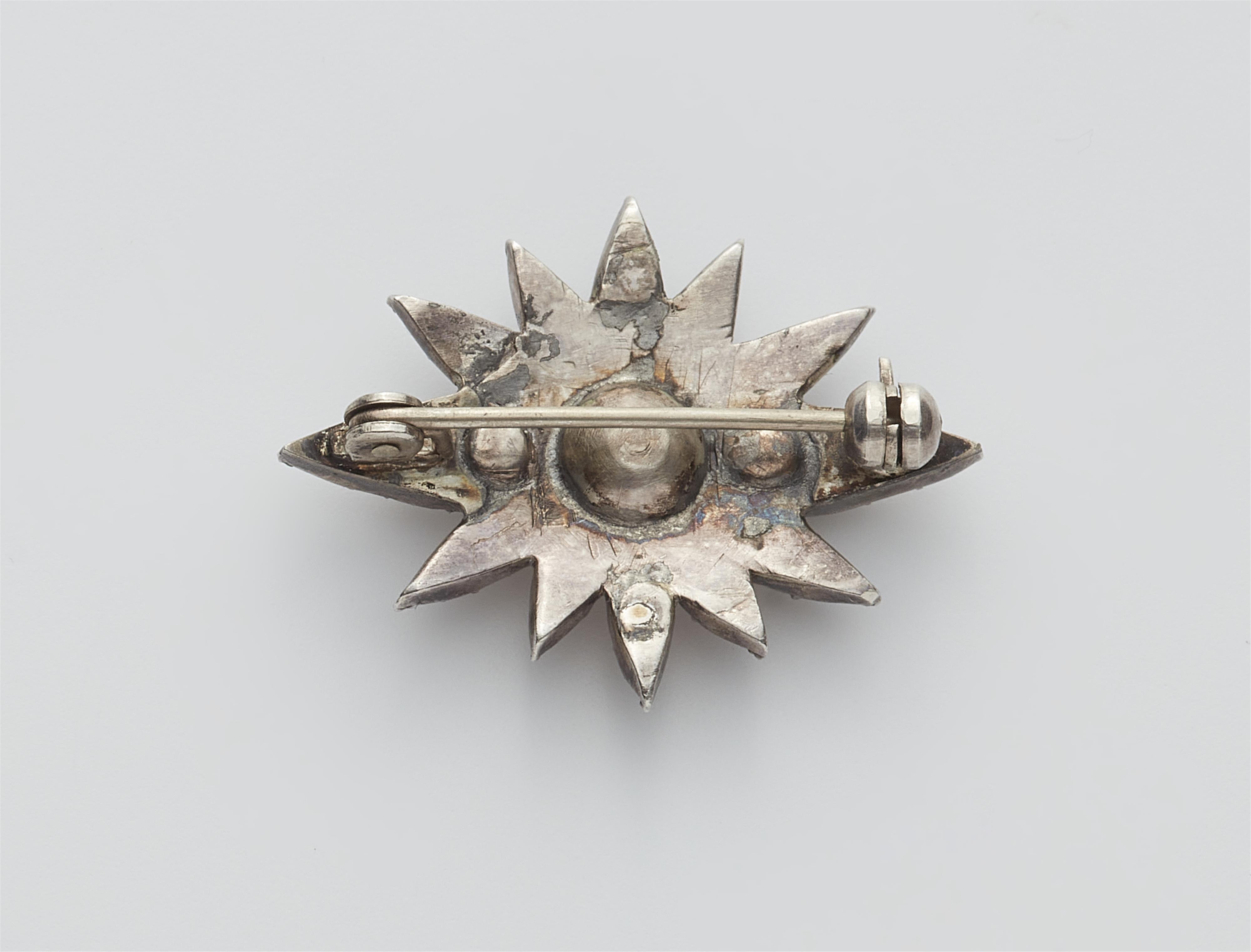 A small silver and cushion-cut diamond star brooch. - image-2