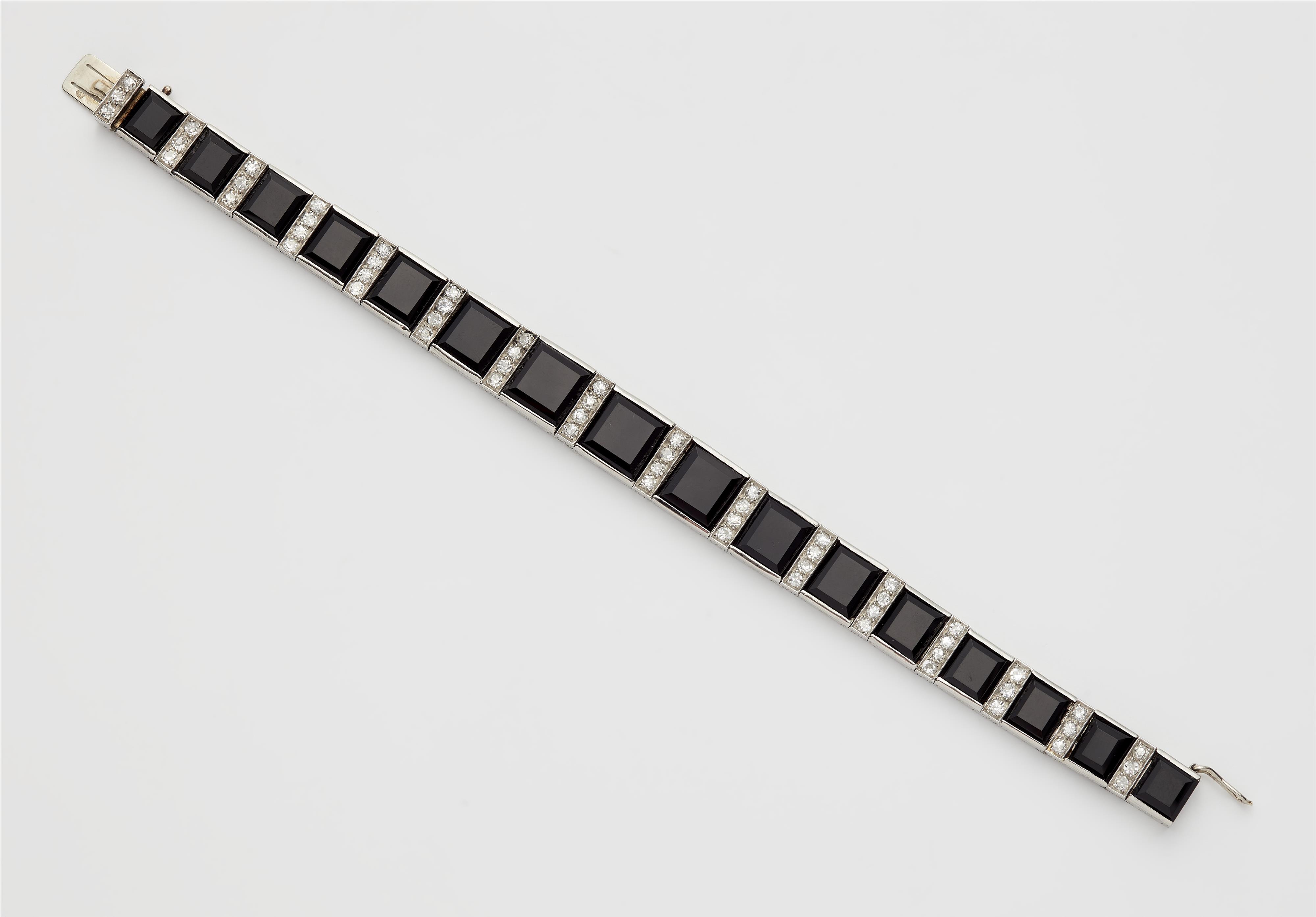 A French Art Déco 18k white gold onyx and diamond bracelet. - image-1