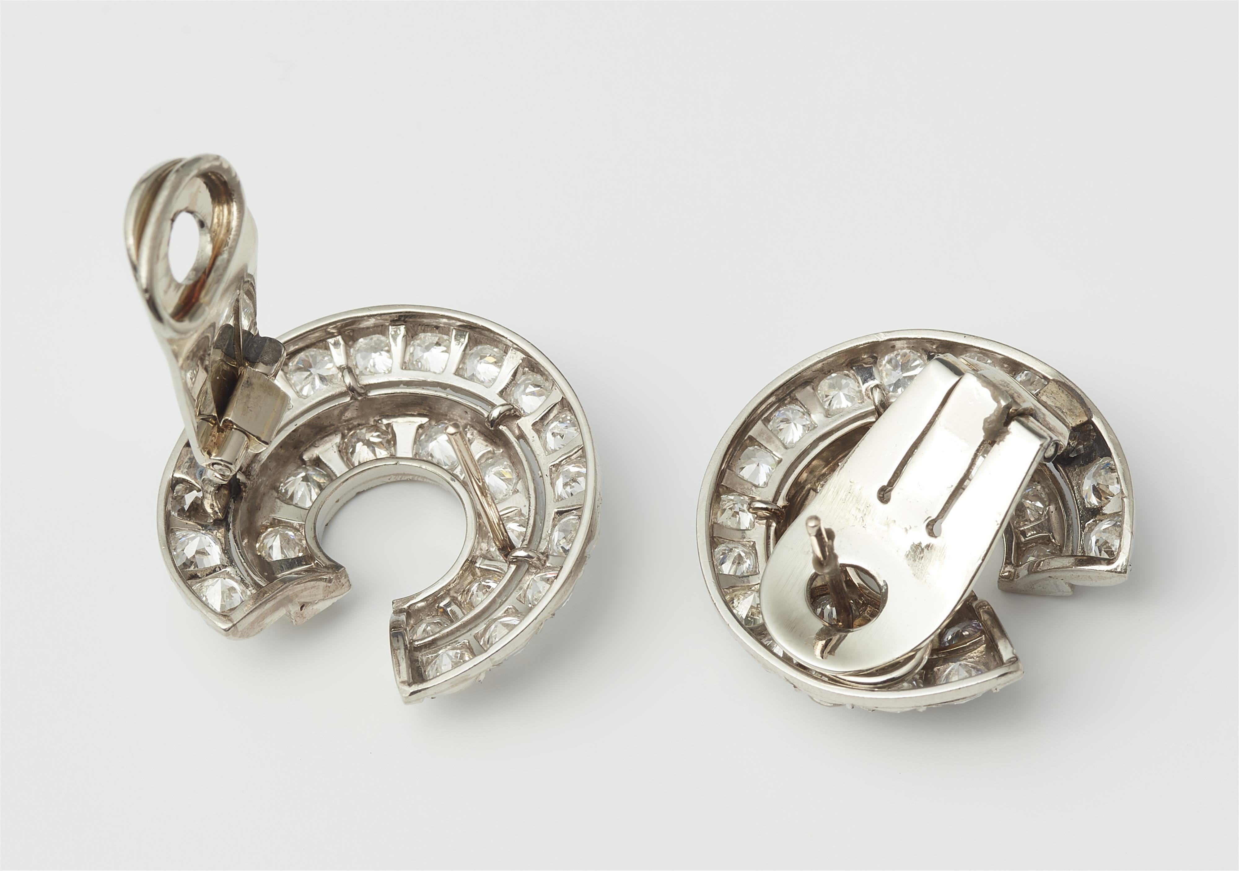 A pair of platinum and diamond swirl clip earrings with diamonds. - image-2