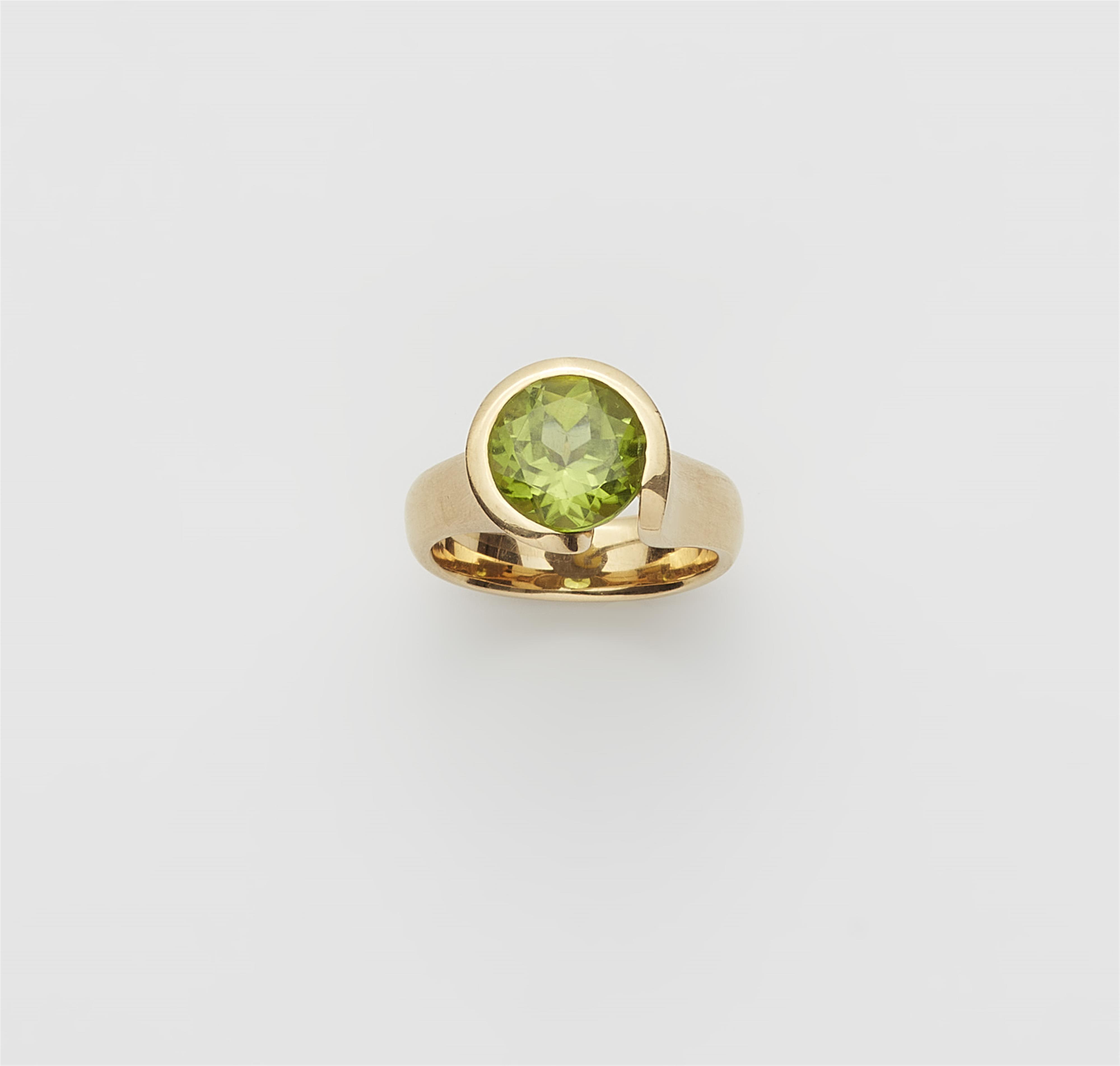 A German 18k gold and peridot ring. - image-1