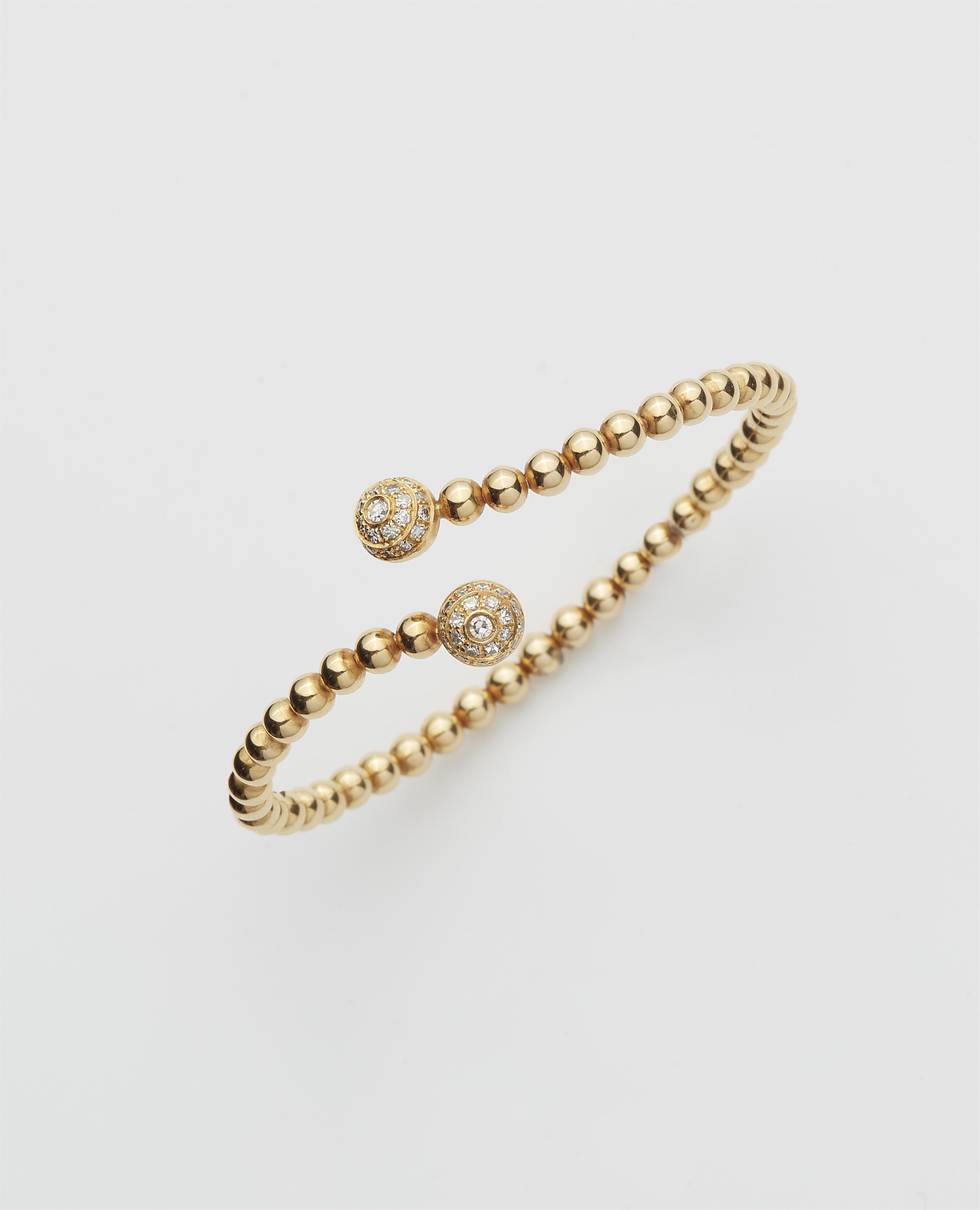 A flexible 18k gold and diamond crossover bangle. - image-1
