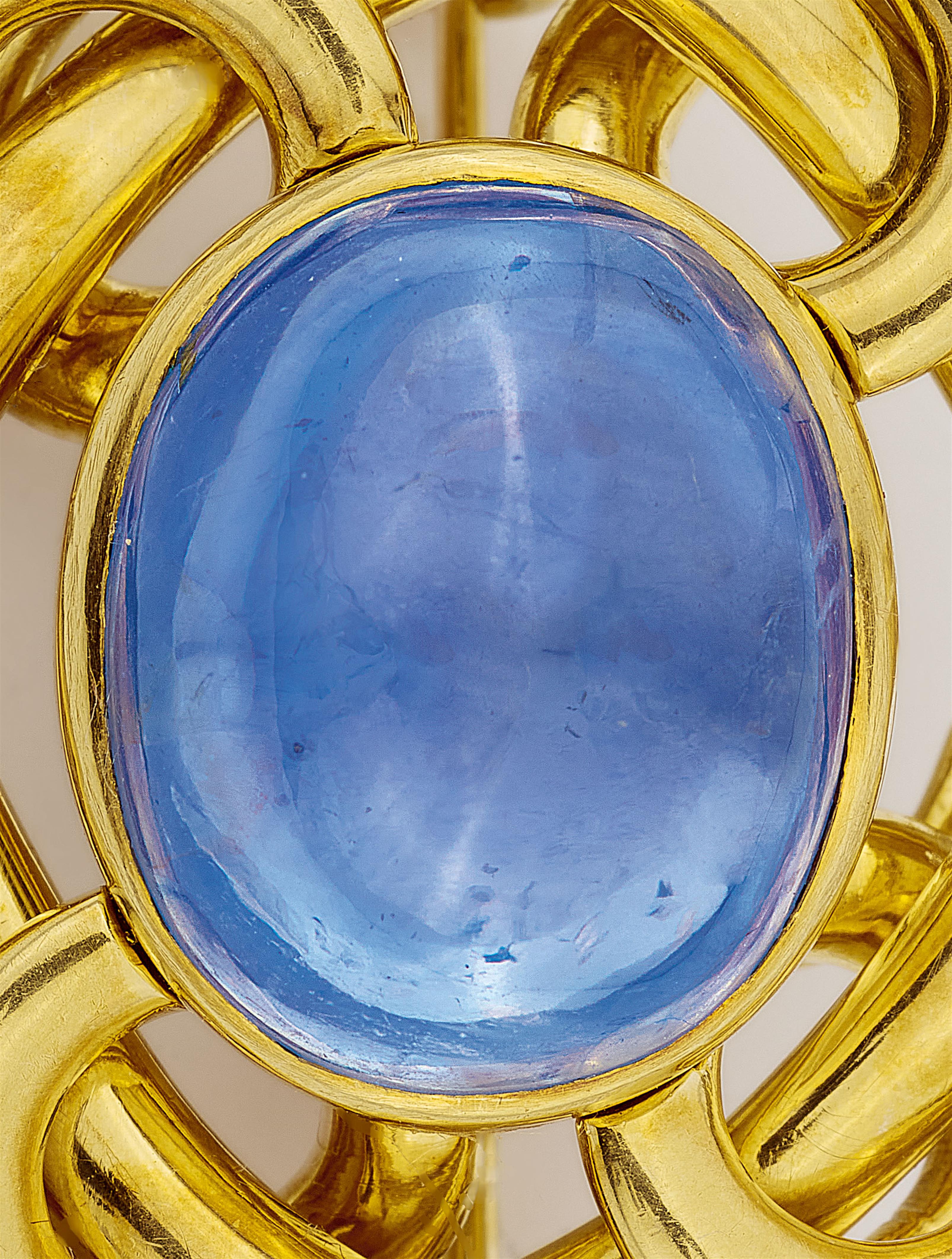 An 18k gold knot brooch with a fine ca. 15 ct Ceylon sapphire cabochon. - image-2