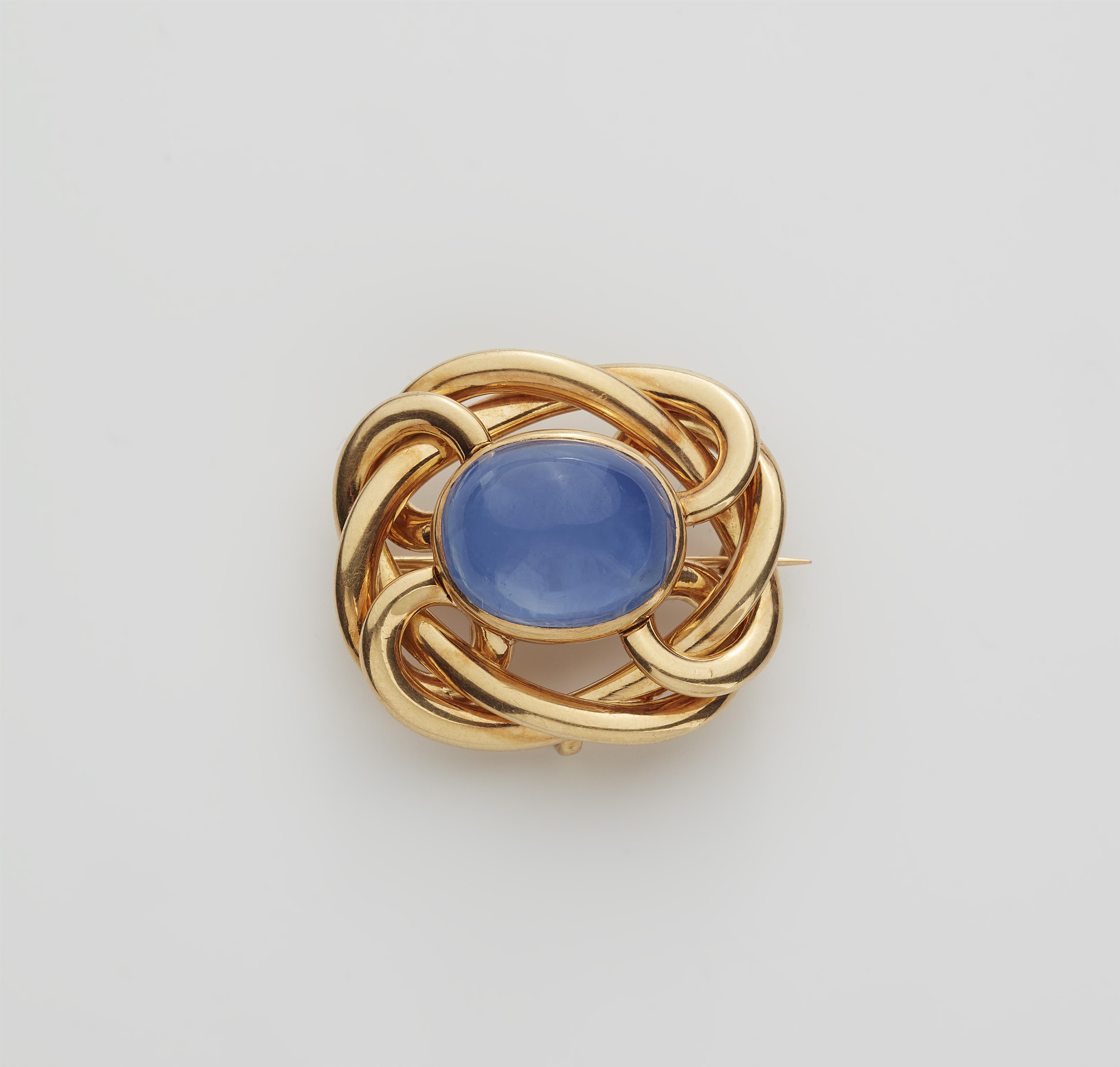 An 18k gold knot brooch with a fine ca. 15 ct Ceylon sapphire cabochon. - image-1