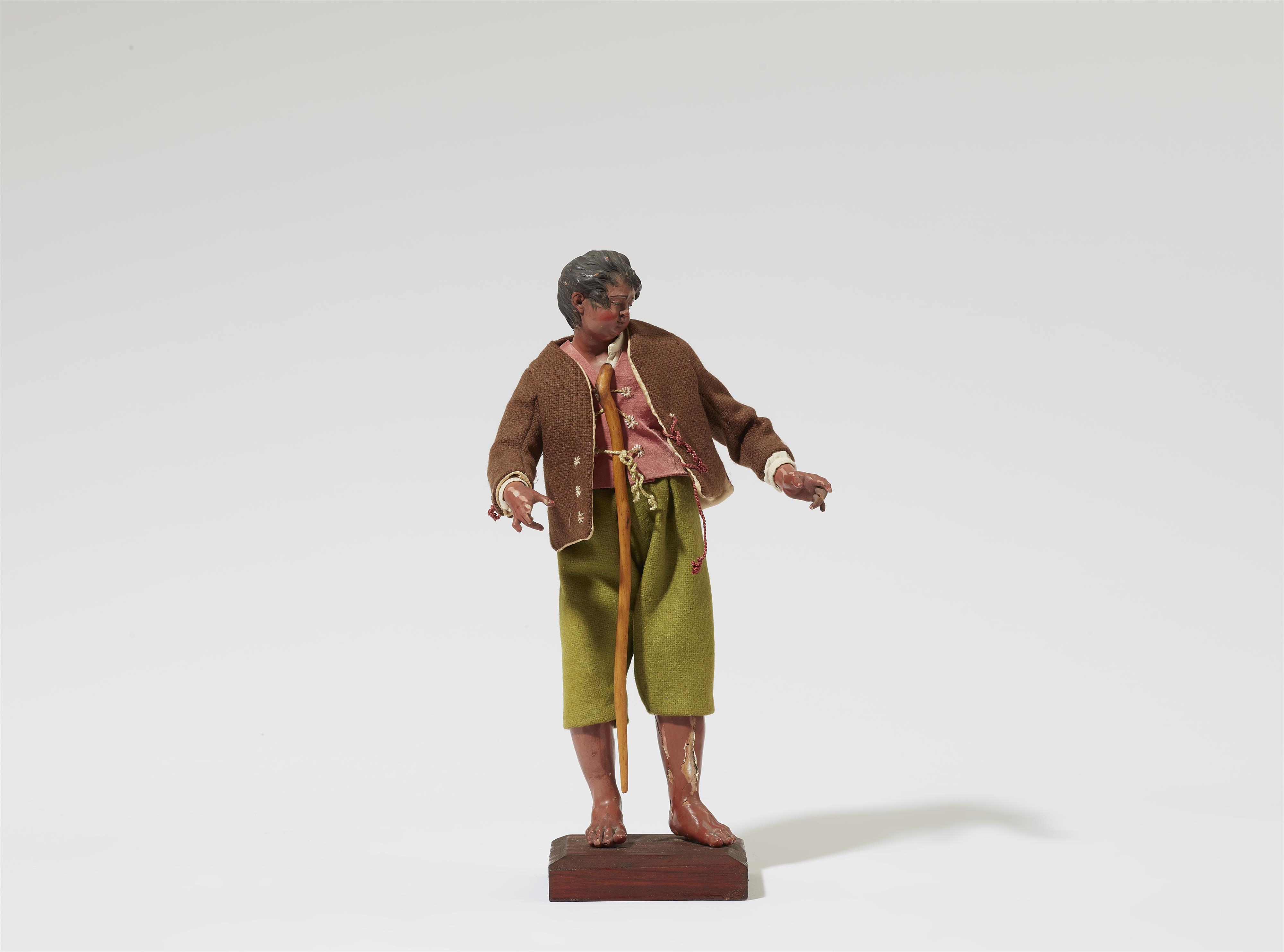 A figure of a shepherd with a crook from a Nativity scene - image-1