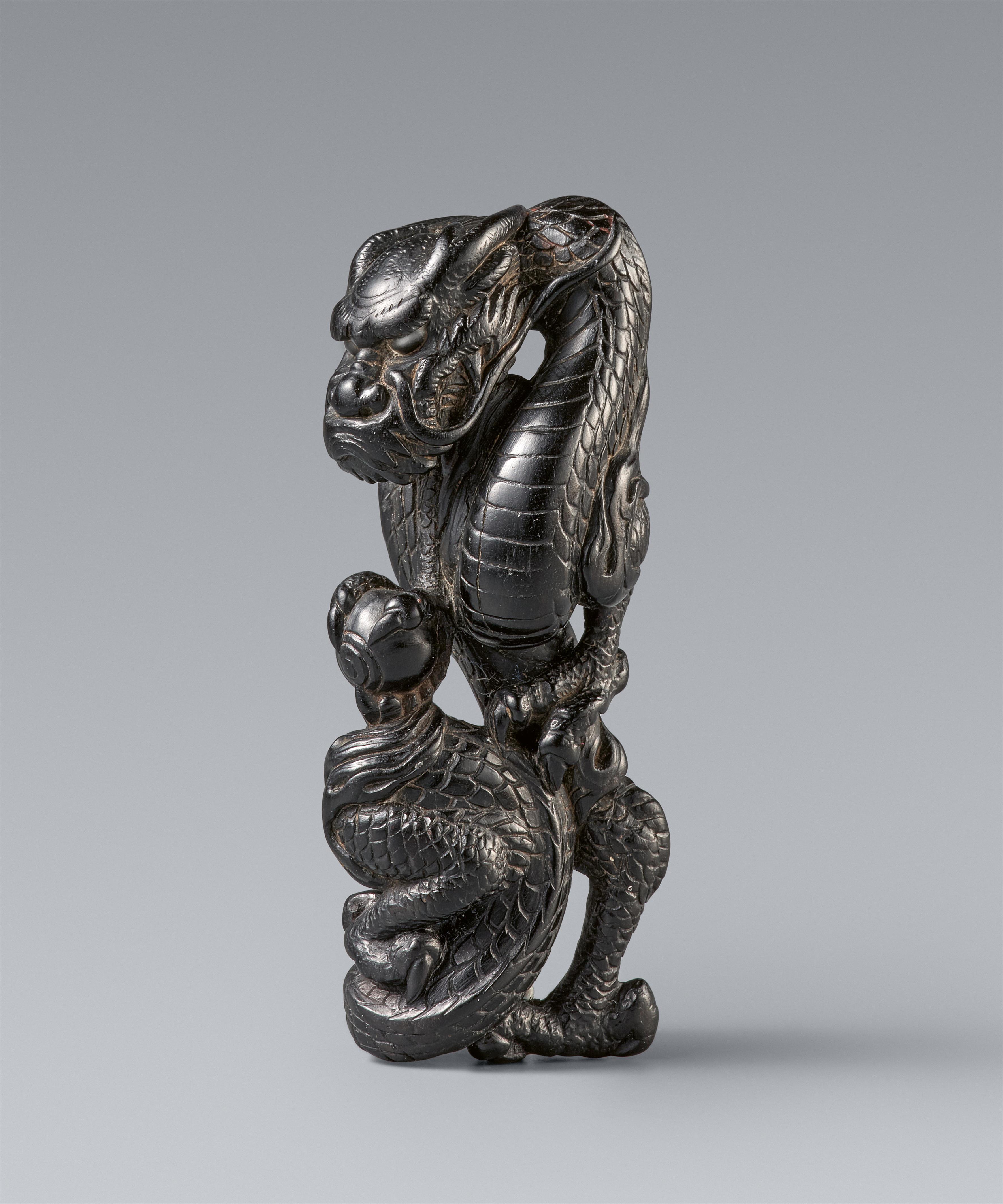 An unusual black wood netsuke of a winding dragon. 19th century - image-1