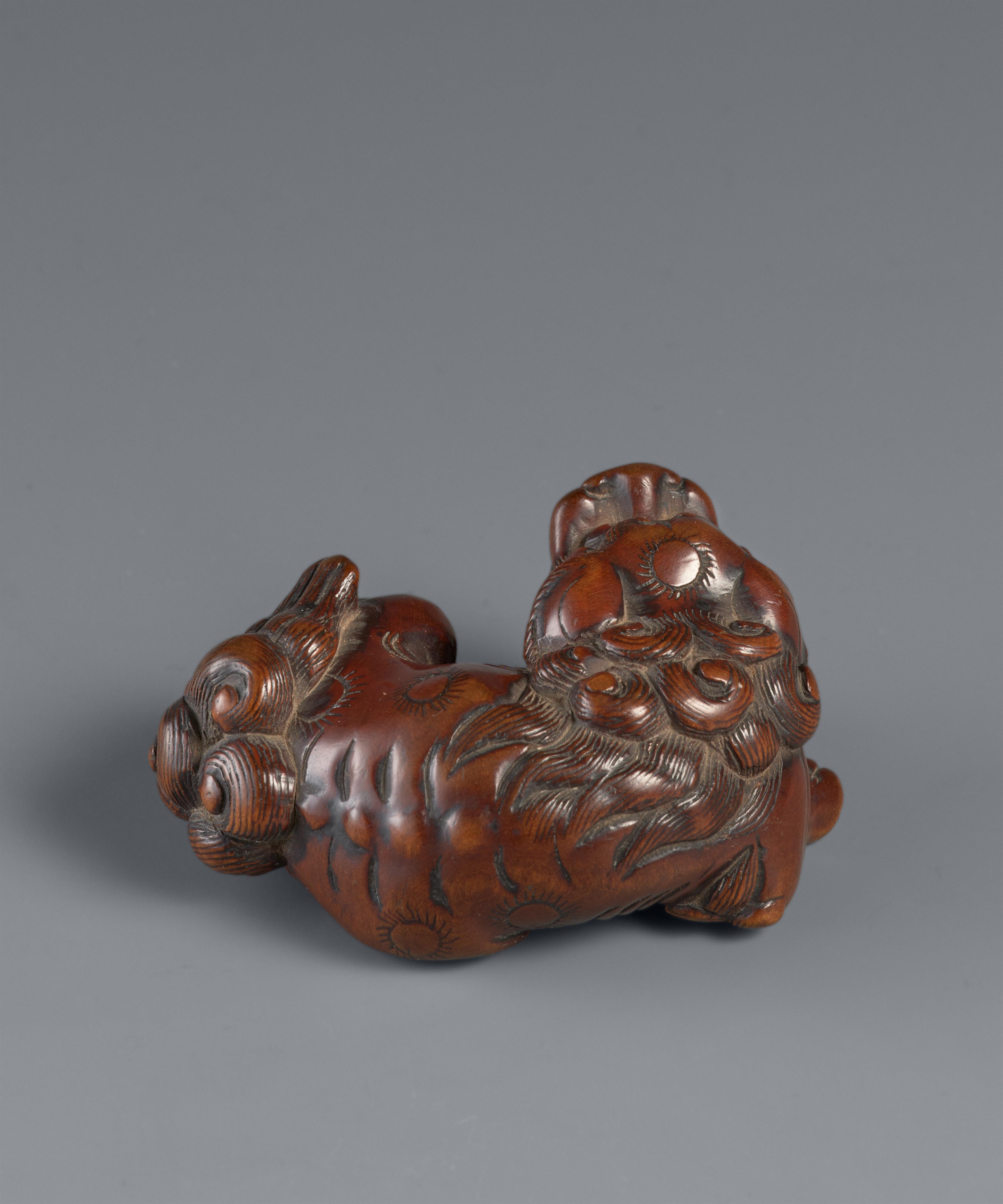 A boxwood netsuke of a reclining shishi. Late 18th century - image-6