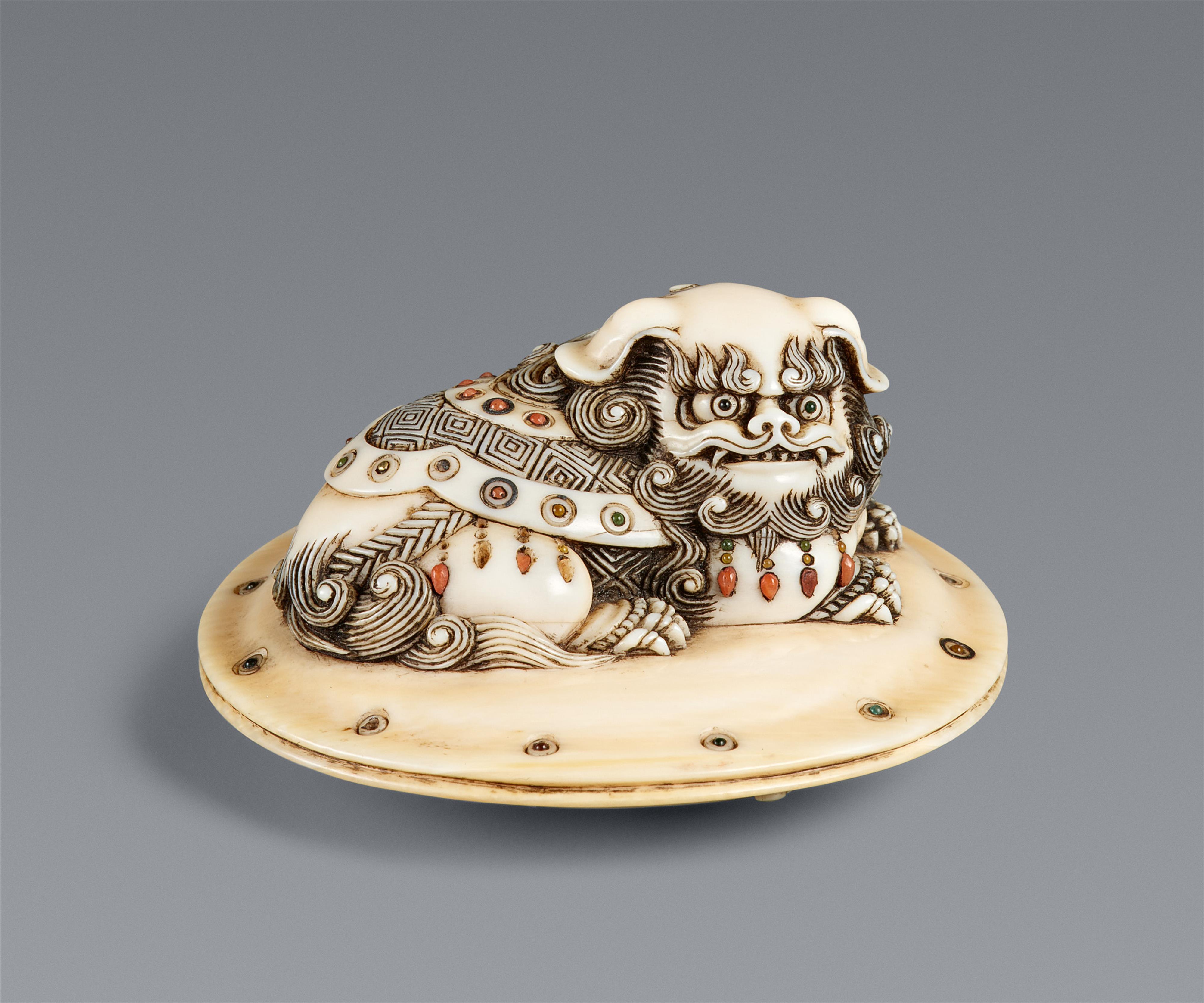 An ivory netsuke of a caparisoned shishi on a cushion. Mid-19th century - image-1