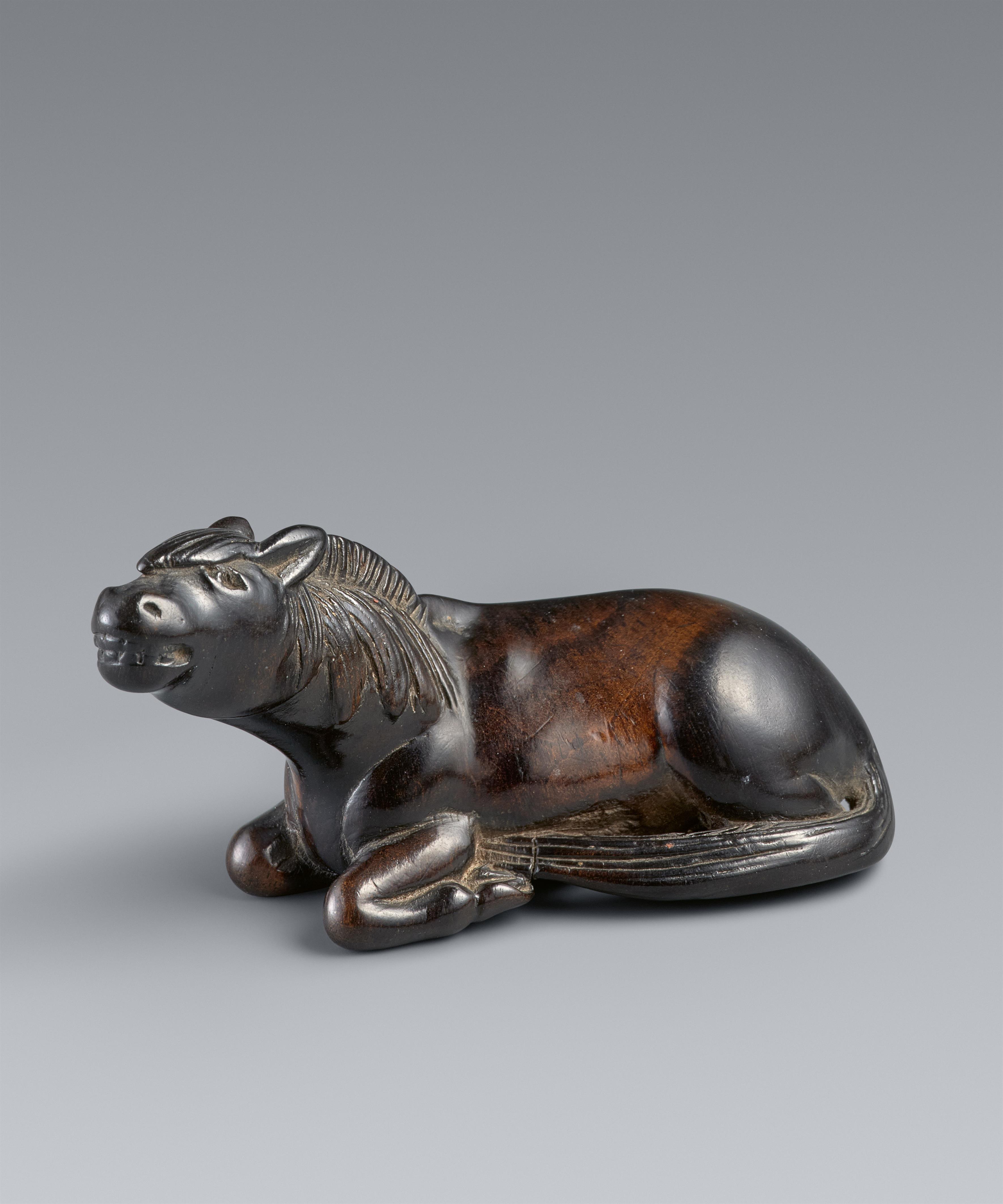 A large probably kaki wood netsuke of a recumbent stallion. 19th century - image-1