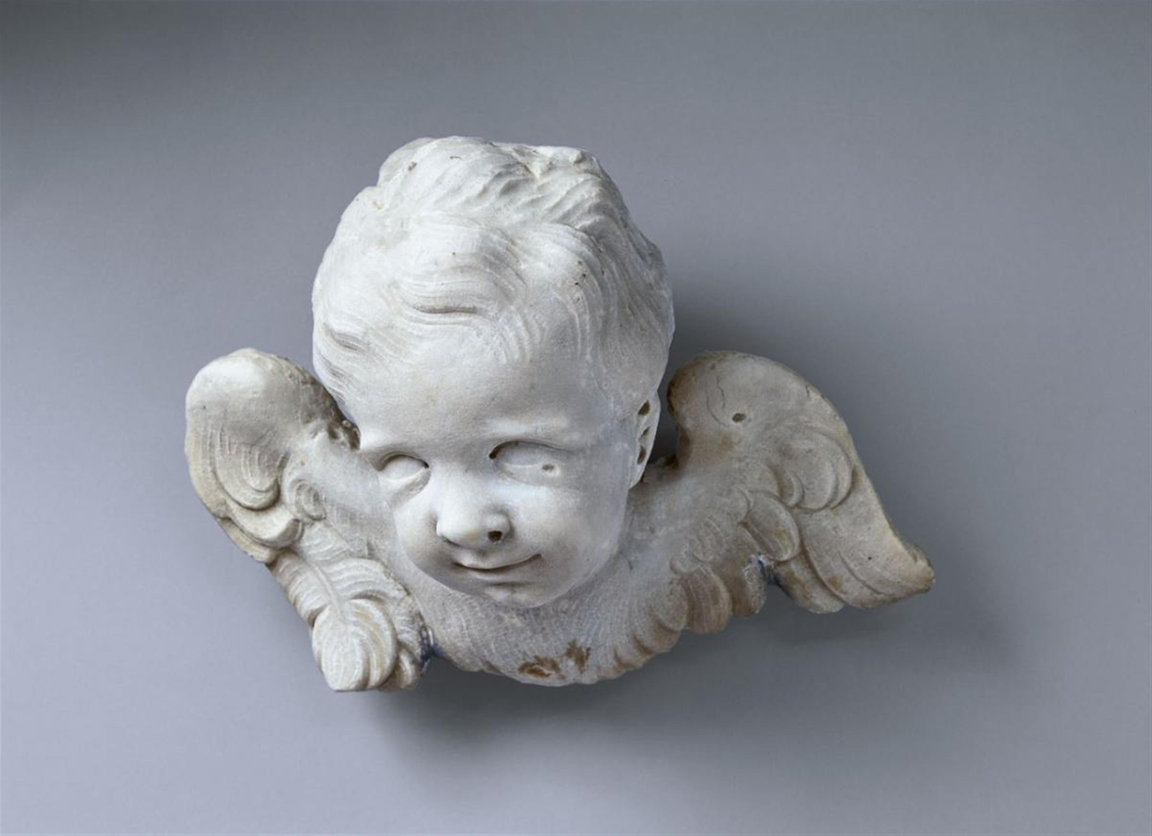A marble WINGED HEAD OF AN ANGEL - image-2