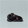 An ebony netsuke of a reclining ox, by Sekiran. Late 19th century - image-1